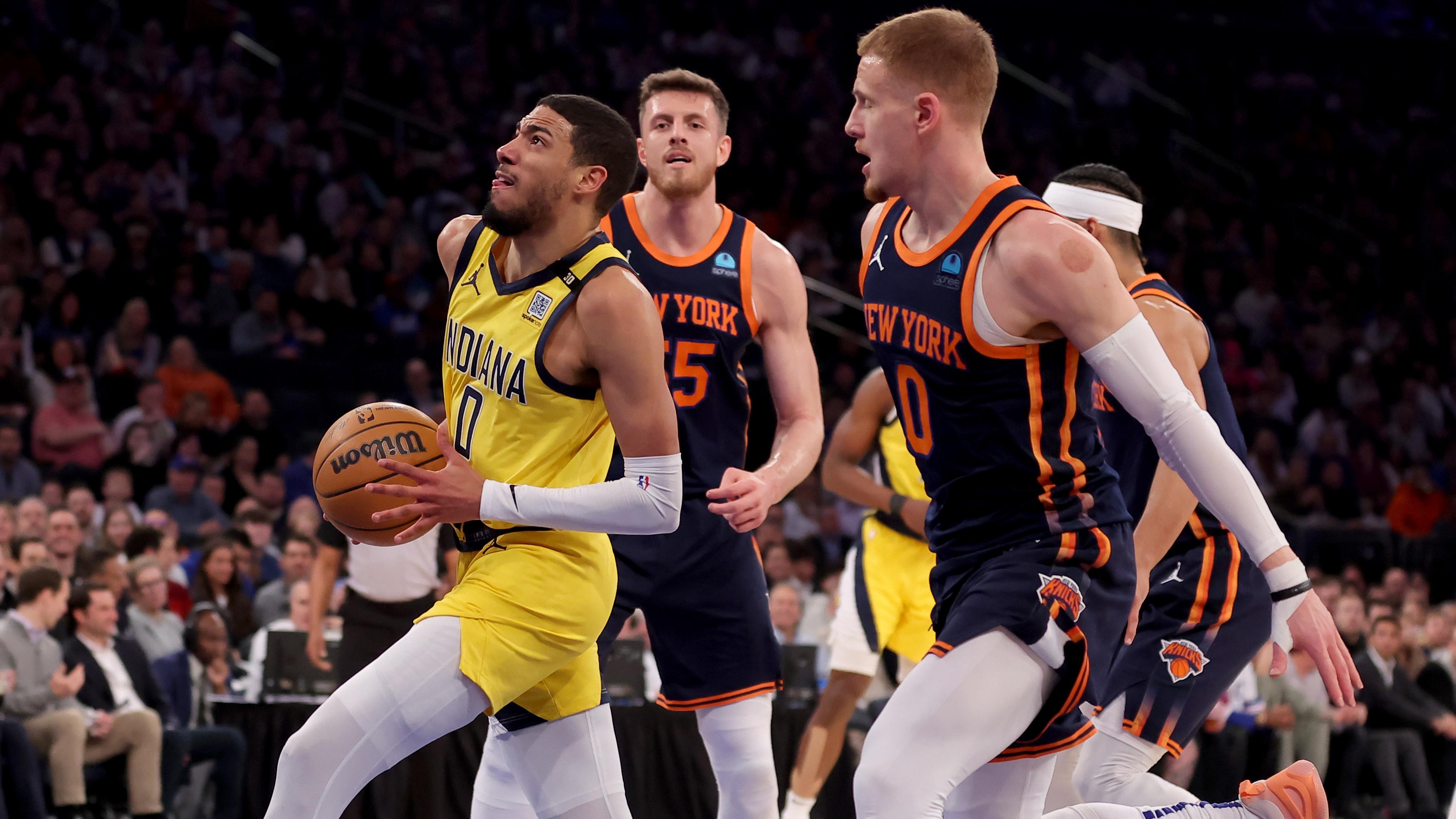 Indiana Pacers guard Tyrese Haliburton (0) drives to the basket against New York Knicks center Isaiah Hartenstein (55) and guard Donte DiVincenzo (0) during the first quarter at Madison Square Garden / Brad Penner - USA TODAY Sports