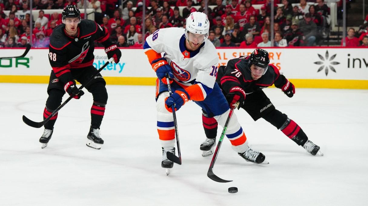 Apr 30, 2024; Raleigh, North Carolina, USA; New York Islanders left wing Pierre Engvall (18) tries to control the puck against Carolina Hurricanes defenseman Brady Skjei (76) during the second period in game five of the first round of the 2024 Stanley Cup Playoffs at PNC Arena. / James Guillory-USA TODAY Sports