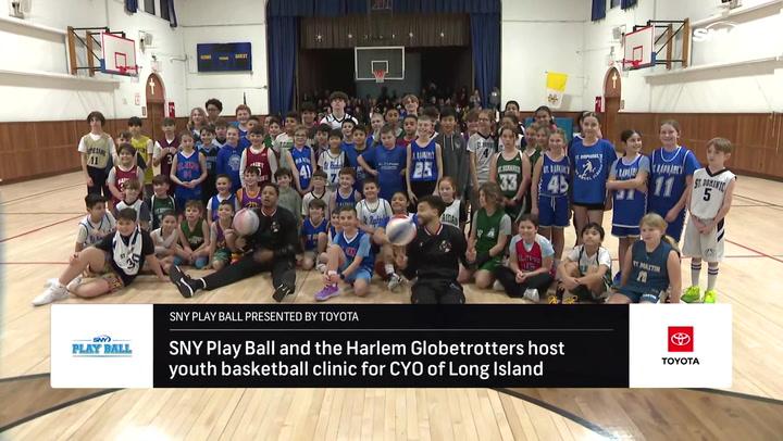 Youth basketball players pose with Harlem Globetrotters at SNY Play Ball clinic on Long Island.