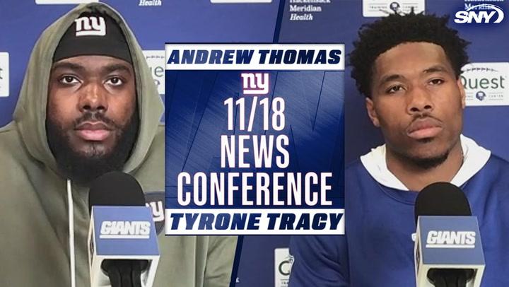 Andrew Thomas and Tyrone Tracy at a Giants news conference on November 18, with microphones and team logos visible.