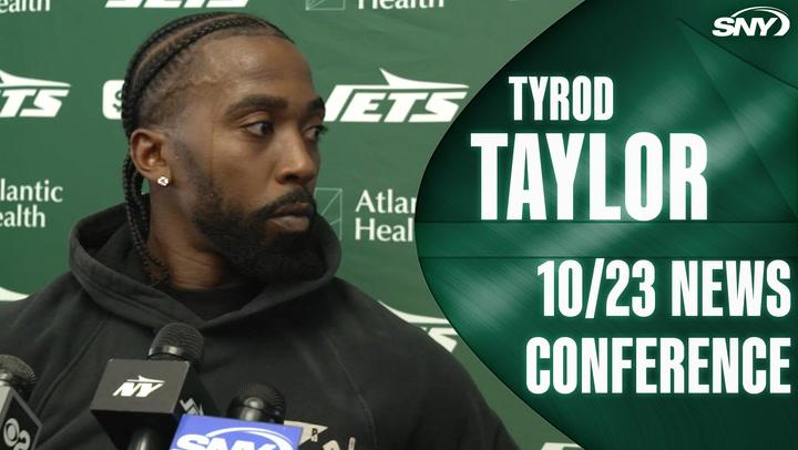 Tyrod Taylor at podium during Jets 10/23 news conference, SNY logo in corner.