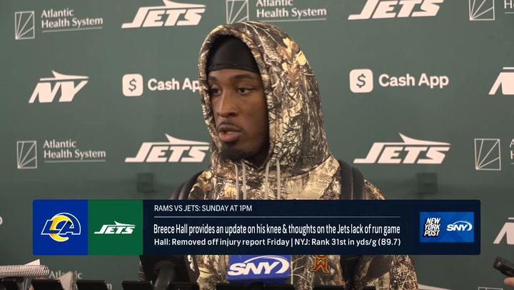 A football player updates the media on his knee, featuring 122024BREECENYP branding backdrop.