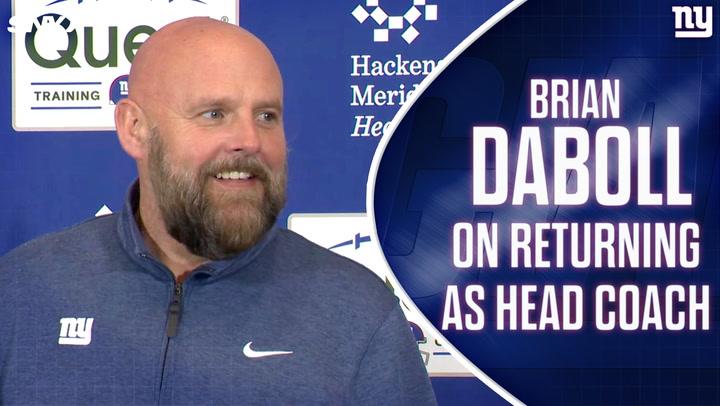 Brian Daboll smiling at a press event about returning as Giants coach, discussing QB search.