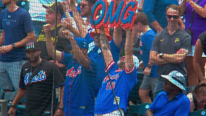 Fans at a baseball game holding an "OMG" sign.