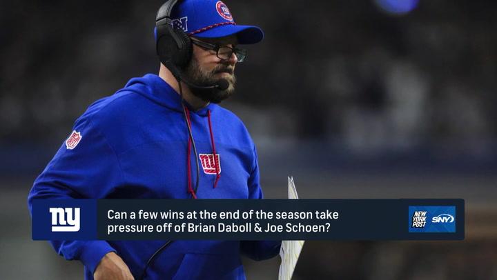 Coach in Giants attire on sideline. Giants aim to relieve coaching pressure in final games.