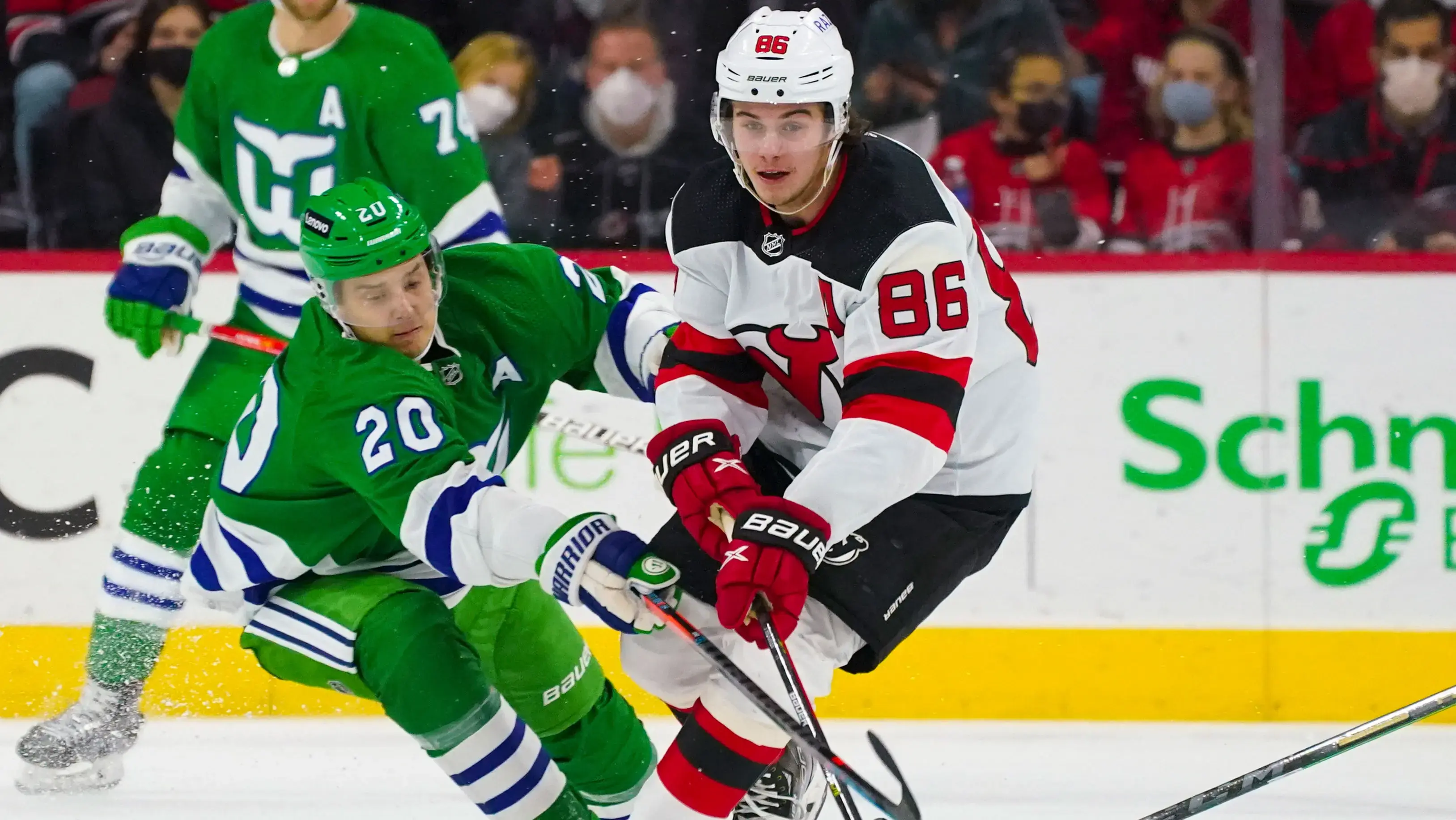 Jan 29, 2022; Raleigh, North Carolina, USA; New Jersey Devils center Jack Hughes (86) tries to control the puck against Carolina Hurricanes center Sebastian Aho (20) first period at PNC Arena. / James Guillory-USA TODAY Sports