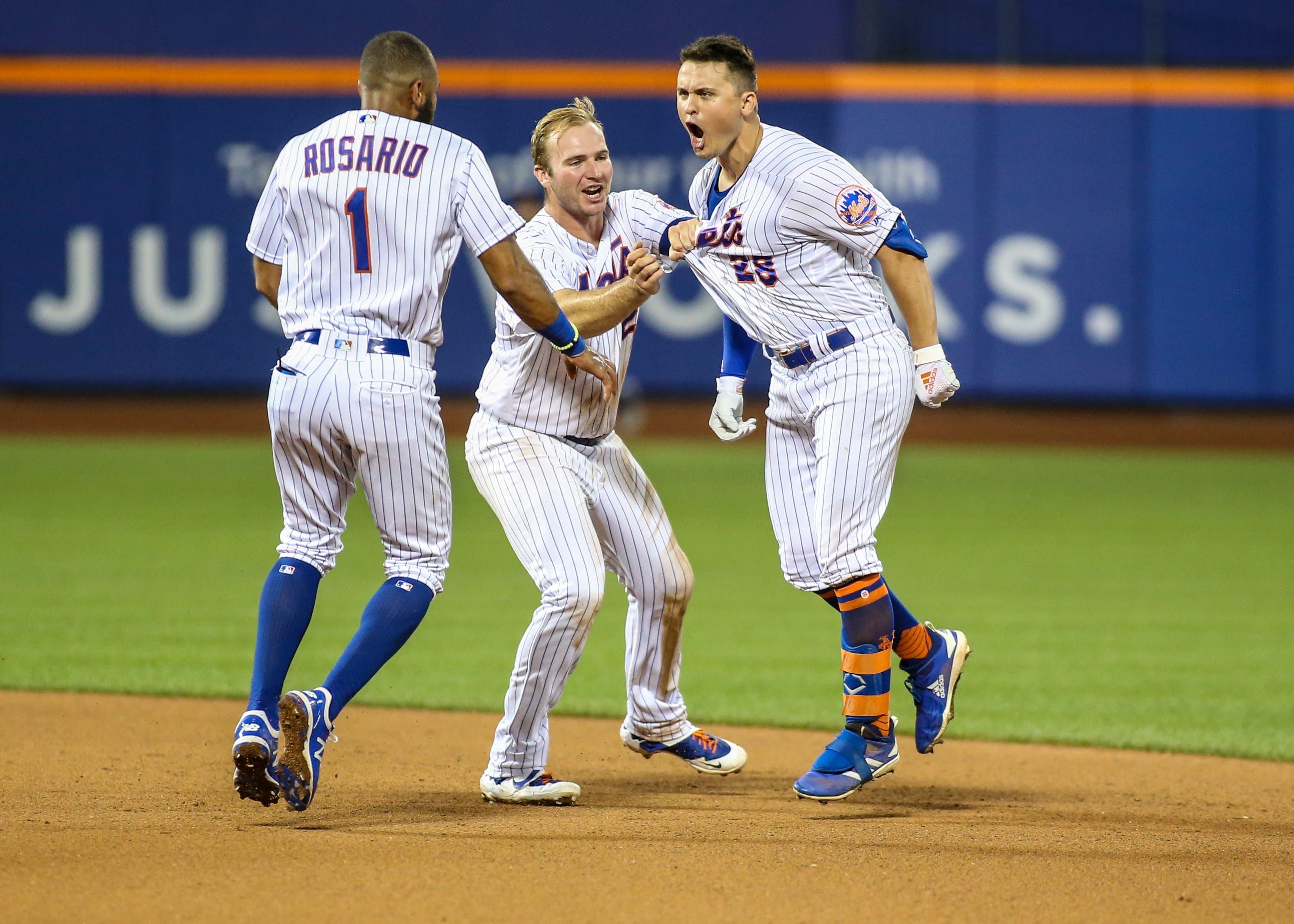 Aug 21, 2019; New York City, NY, USA; New York Mets left fielder J.D. Davis (28) celebrates with first baseman Pete Alonzo (20) and shortstop Amed Rosario (1) after hitting a game winning RBI single in the tenth inning to defeat the Cleveland Indians at Citi Field. Mandatory Credit: Wendell Cruz-USA TODAY Sportsundefined