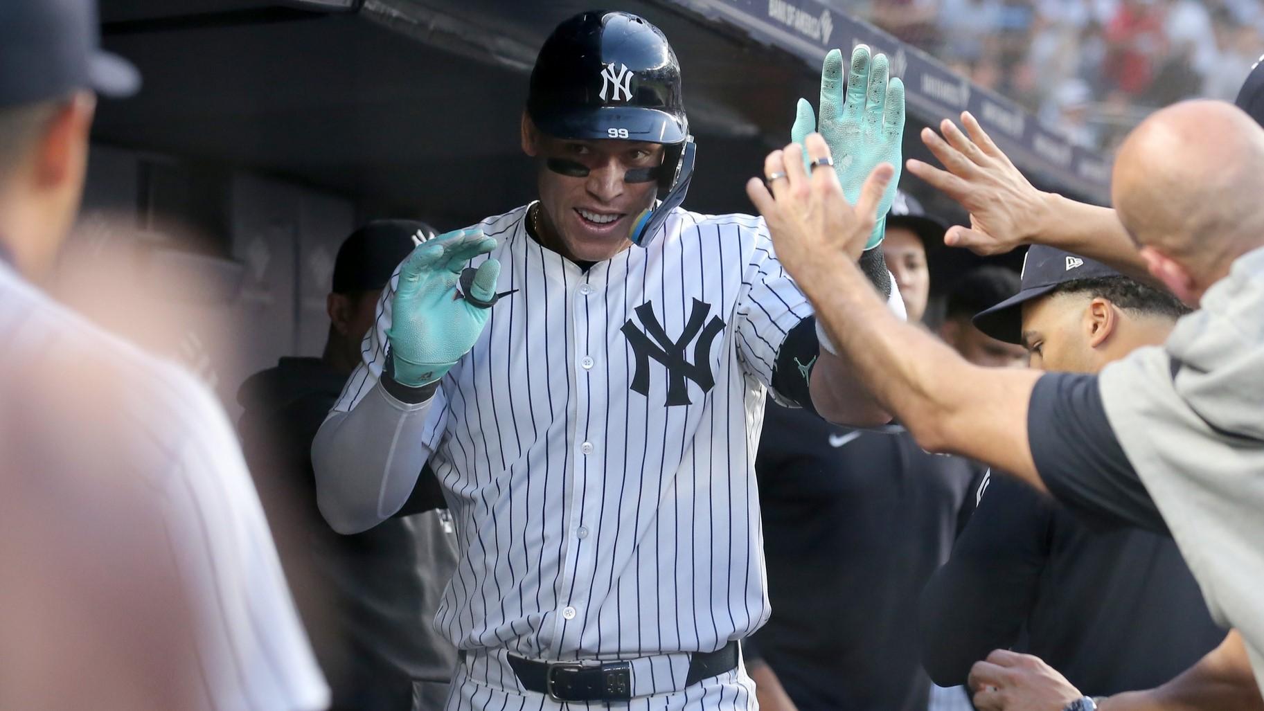 May 8, 2024; Bronx, New York, USA; New York Yankees center fielder Aaron Judge (99) celebrates his solo home run against the Houston Astros with teammates in the dugout during the third inning at Yankee Stadium. / Brad Penner-USA TODAY Sports