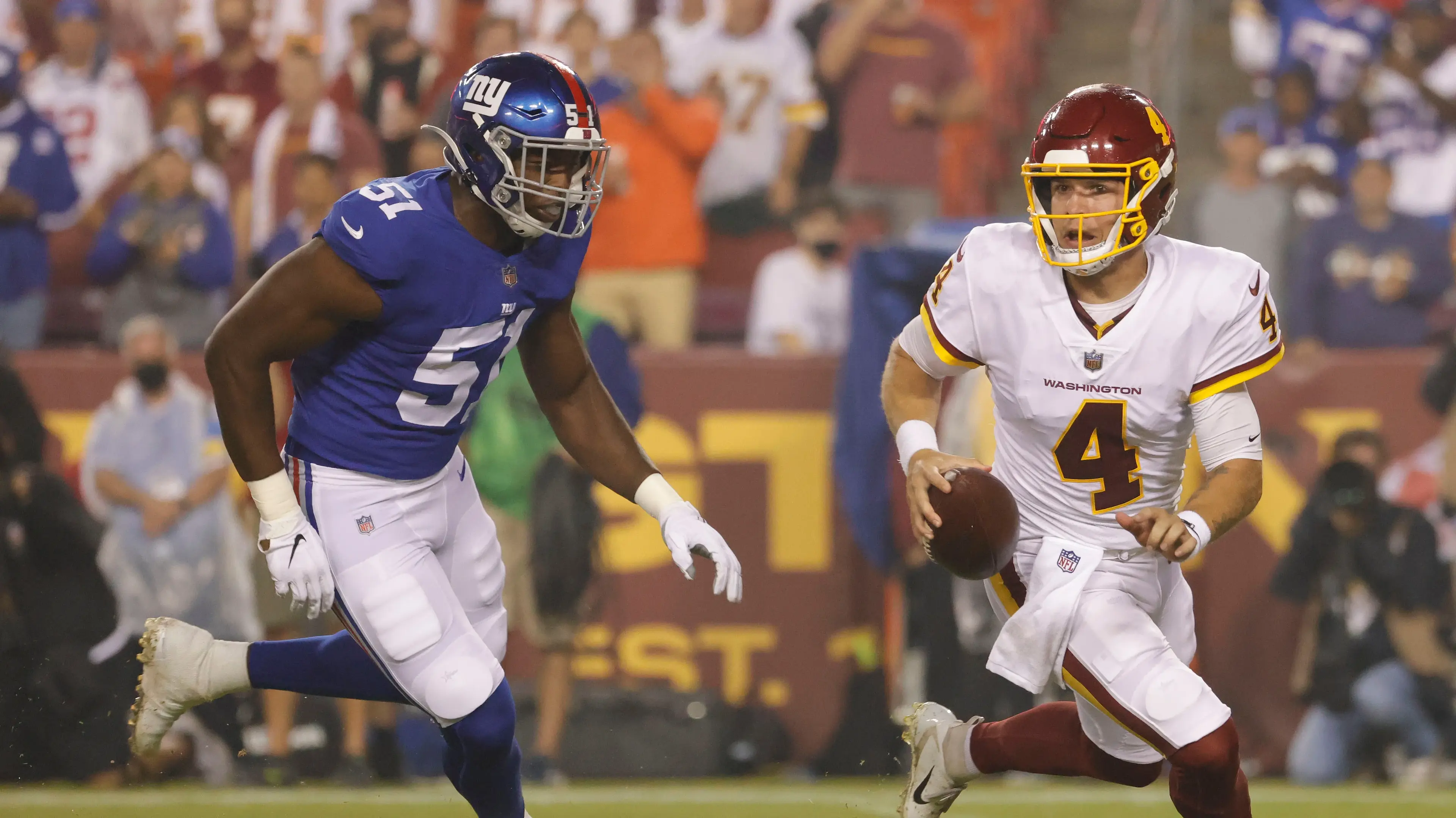 Washington Football Team quarterback Taylor Heinicke (4) is chased by New York Giants linebacker Azeez Ojulari (51) in the first quarter at FedExField. / Geoff Burke - USA TODAY Sports