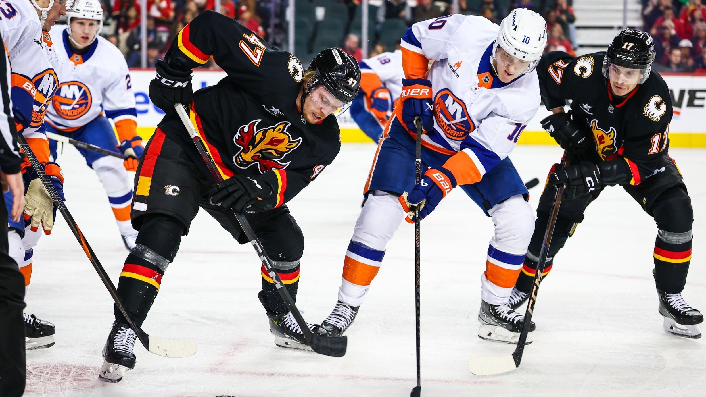 Nov 19, 2024; Calgary, Alberta, CAN; Calgary Flames center Connor Zary (47) and New York Islanders right wing Simon Holmstrom (10) battles for the puck during the second period at Scotiabank Saddledome. / Sergei Belski-Imagn Images