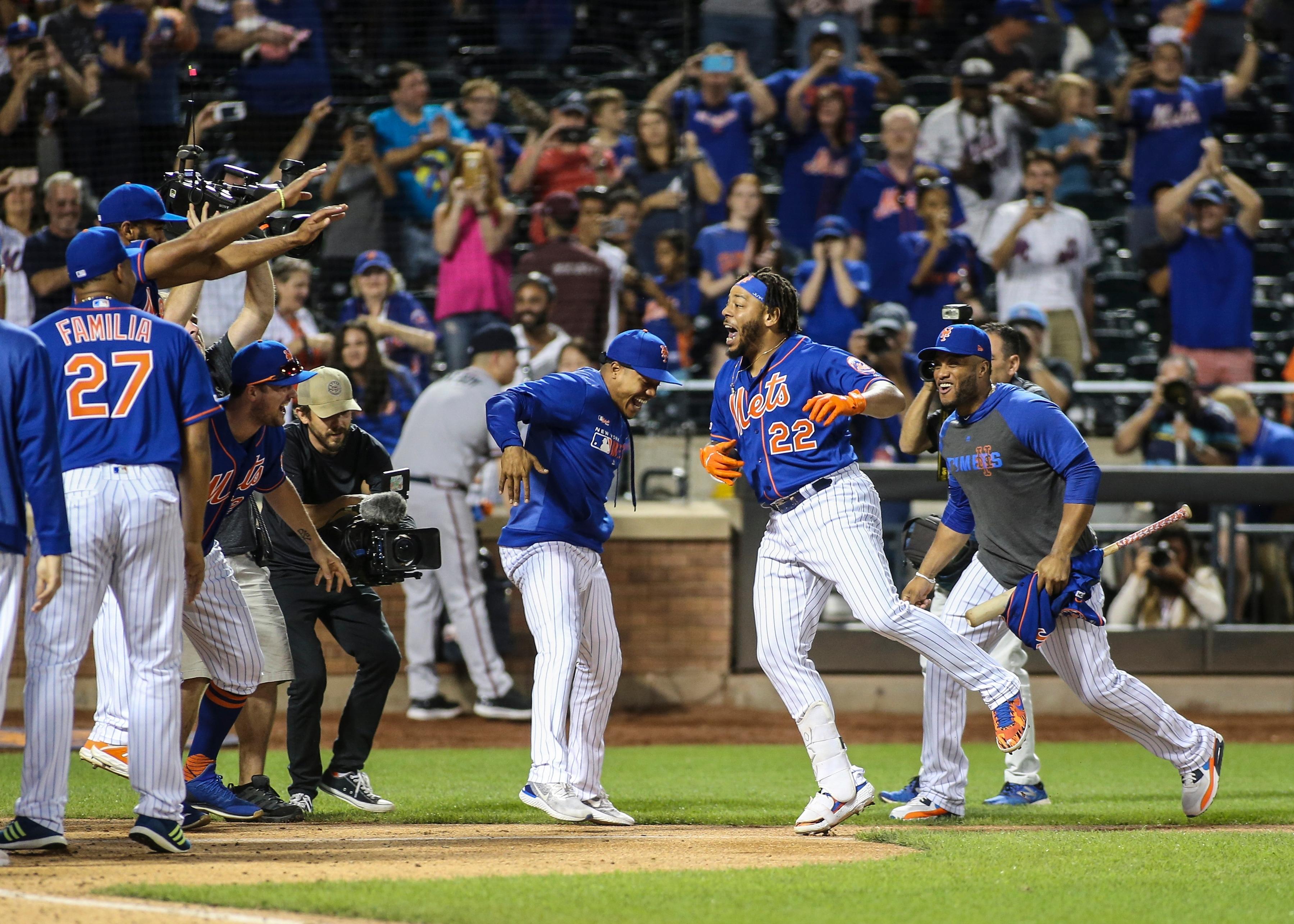 Sep 29, 2019; New York City, NY, USA; New York Mets first baseman Dominic Smith (22) is greeted by his teammates after hitting a walk off three run home run to defeat the Atlanta Braves in the eleventh inning at Citi Field. Mandatory Credit: Wendell Cruz-USA TODAY Sports