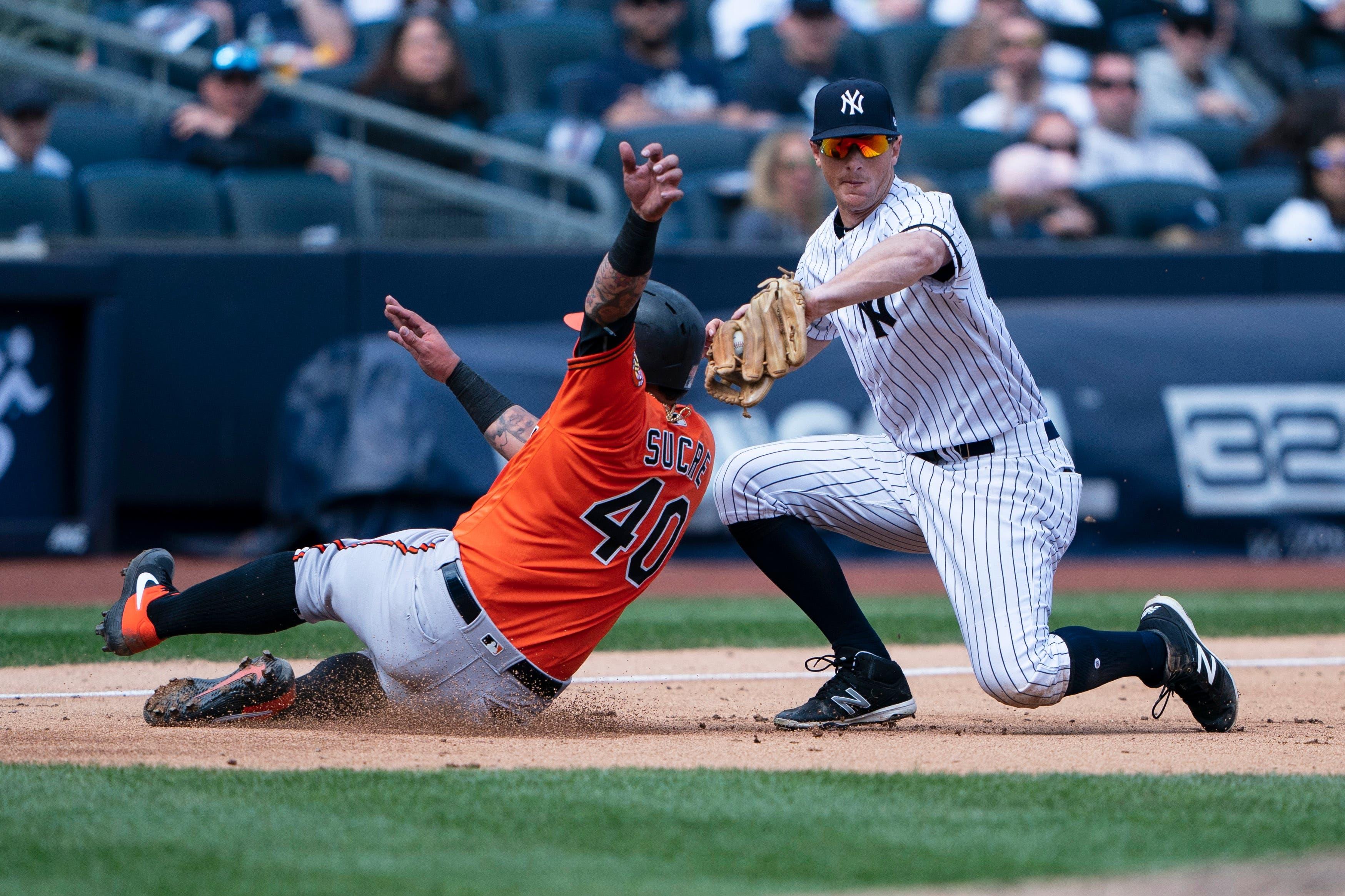 Mar 30, 2019; Bronx, NY, USA; Baltimore Orioles catcher Jesus Sucre (40) avoids a tag by New York Yankees third baseman DJ LeMahieu (26) to advance to third base on a fly ball during the sixth inning at Yankee Stadium. Mandatory Credit: Gregory J. Fisher-USA TODAY Sports / Gregory Fisher