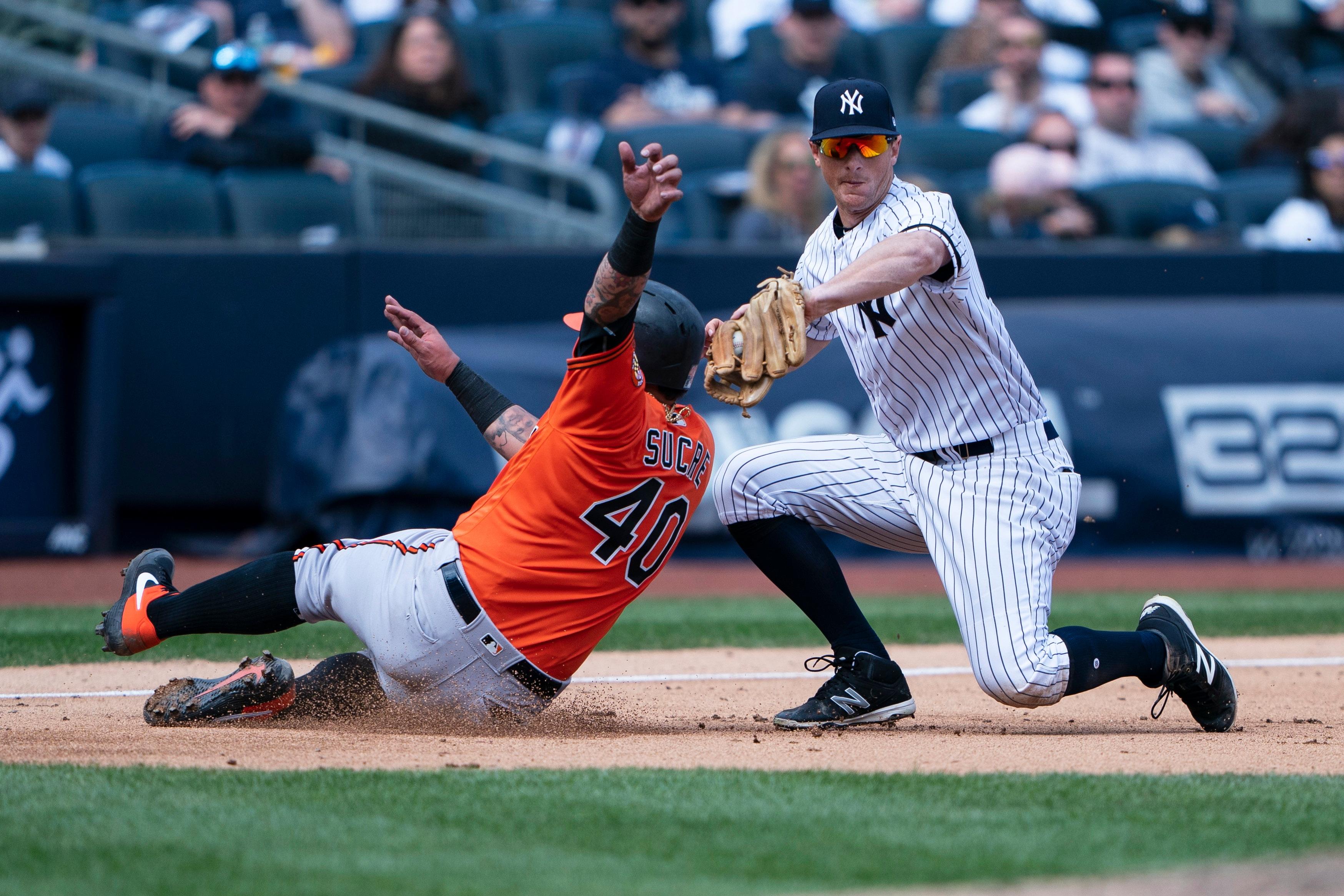 Mar 30, 2019; Bronx, NY, USA; Baltimore Orioles catcher Jesus Sucre (40) avoids a tag by New York Yankees third baseman DJ LeMahieu (26) to advance to third base on a fly ball during the sixth inning at Yankee Stadium. Mandatory Credit: Gregory J. Fisher-USA TODAY Sports