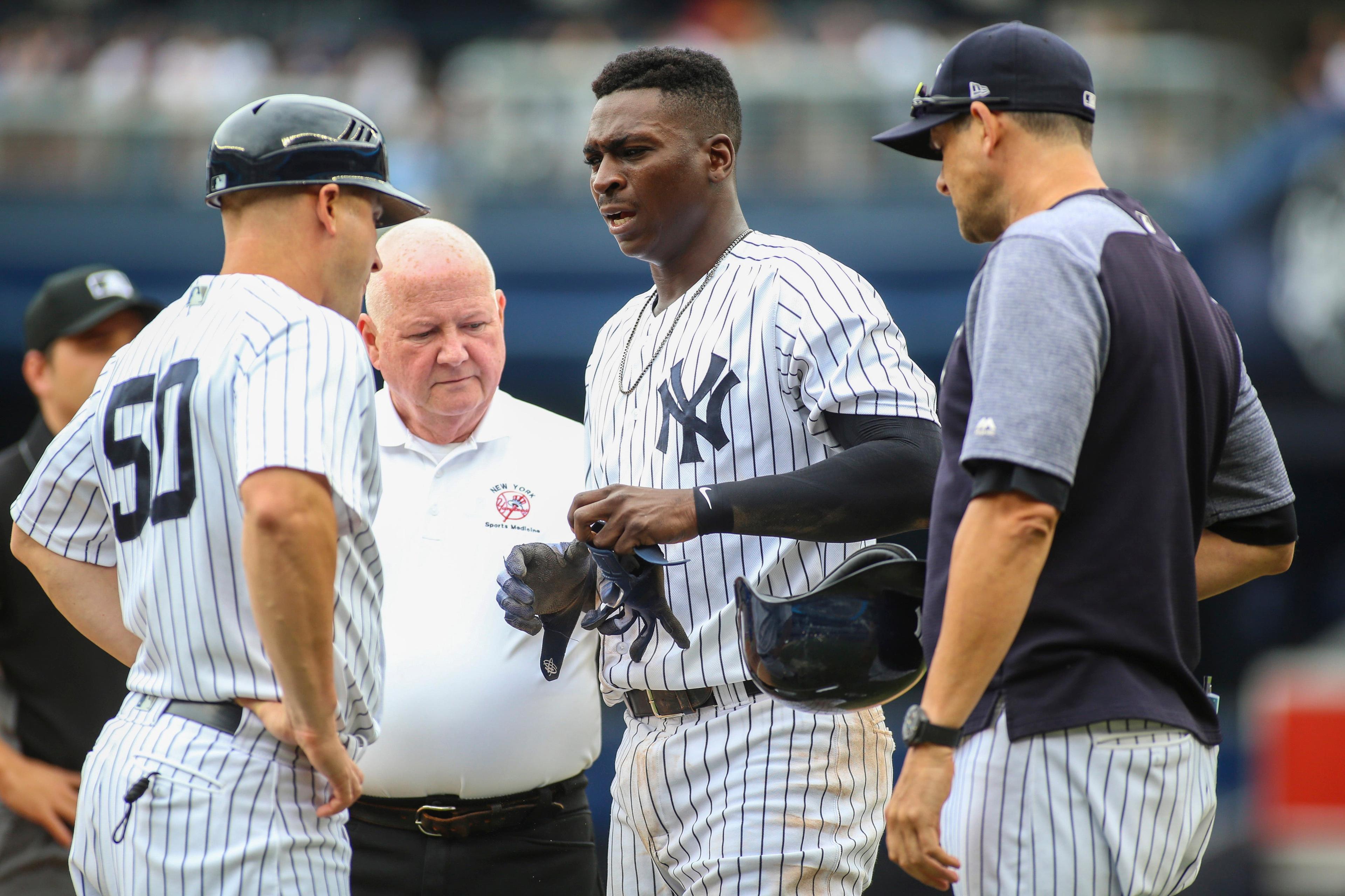 Aug 19, 2018; Bronx, NY, USA; New York Yankees shortstop Didi Gregorius (18) is checked out by first base coach Reggie Willits (50) and manager Aaron Boone (right) after his collision at first base against the Toronto Blue Jays at Yankee Stadium. Mandatory Credit: Wendell Cruz-USA TODAY Sports / Wendell Cruz