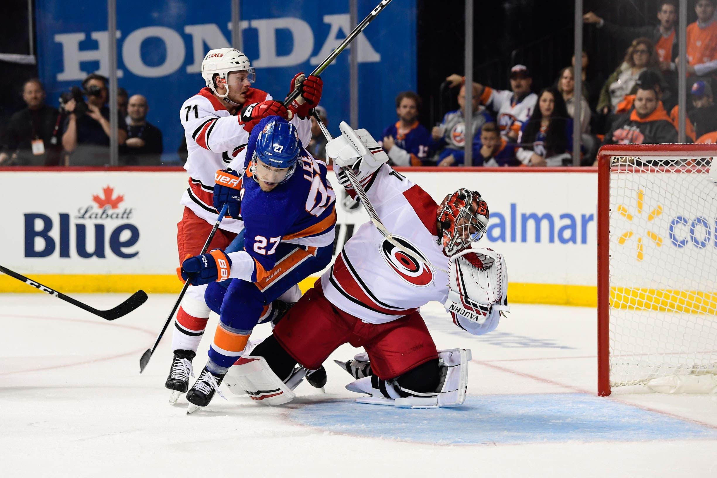 Apr 26, 2019; Brooklyn, NY, USA; Carolina Hurricanes goalie Petr Mrazek (34) is knocked over by New York Islanders left wing Anders Lee (27) during the second period in game one of the second round of the 2019 Stanley Cup Playoffs at Barclays Center. Mandatory Credit: Catalina Fragoso-USA TODAY Sports / Catalina Fragoso