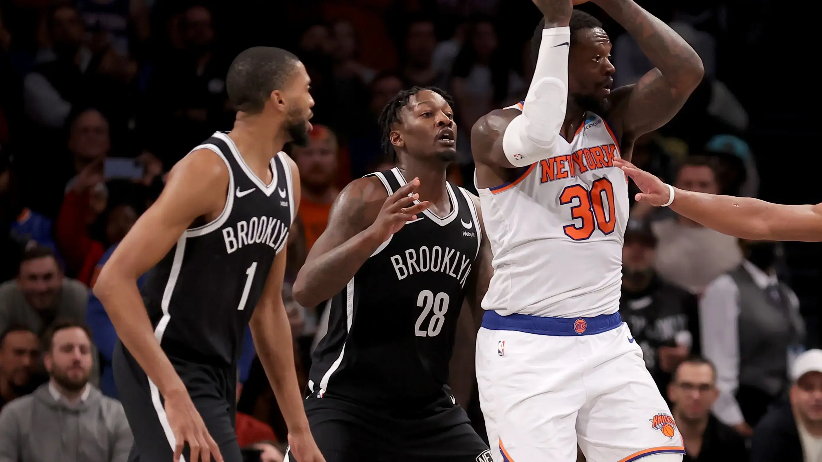 Jan 23, 2024; Brooklyn, New York, USA; New York Knicks forward Julius Randle (30) looks to pass the ball against Brooklyn Nets forwards Mikal Bridges (1) and Dorian Finney-Smith (28) and guard Dennis Smith Jr. (4) during the fourth quarter at Barclays Center. Mandatory Credit: Brad Penner-USA TODAY Sports