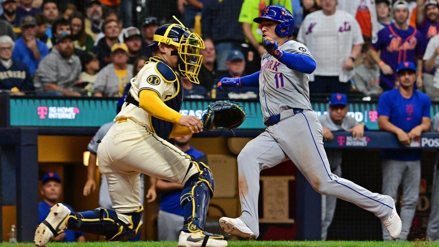 Oct 1, 2024; Milwaukee, Wisconsin, USA; New York Mets second base Jose Iglesias (11) slides safely into home plate against Milwaukee Brewers catcher William Contreras (24) during the fifth inning in game one of the Wildcard round for the 2024 MLB Playoffs at American Family Field. / Benny Sieu-Imagn Images