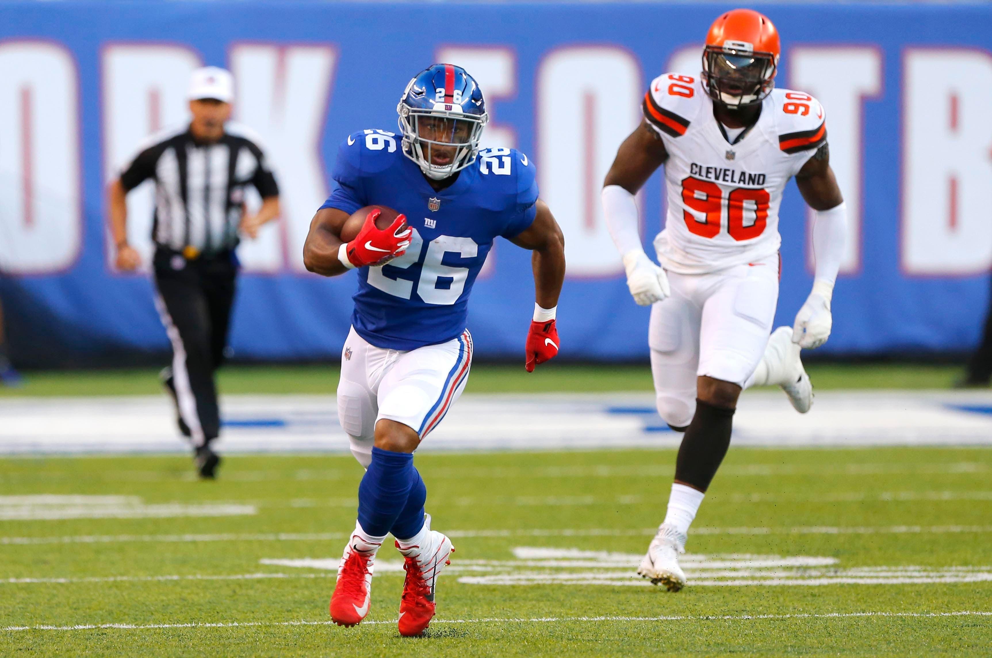 New York Giants running back Saquon Barkley rushes against Cleveland Browns defensive end Emmanuel Ogbah during first half at MetLife Stadium. / Noah K. Murray/USA TODAY Sports