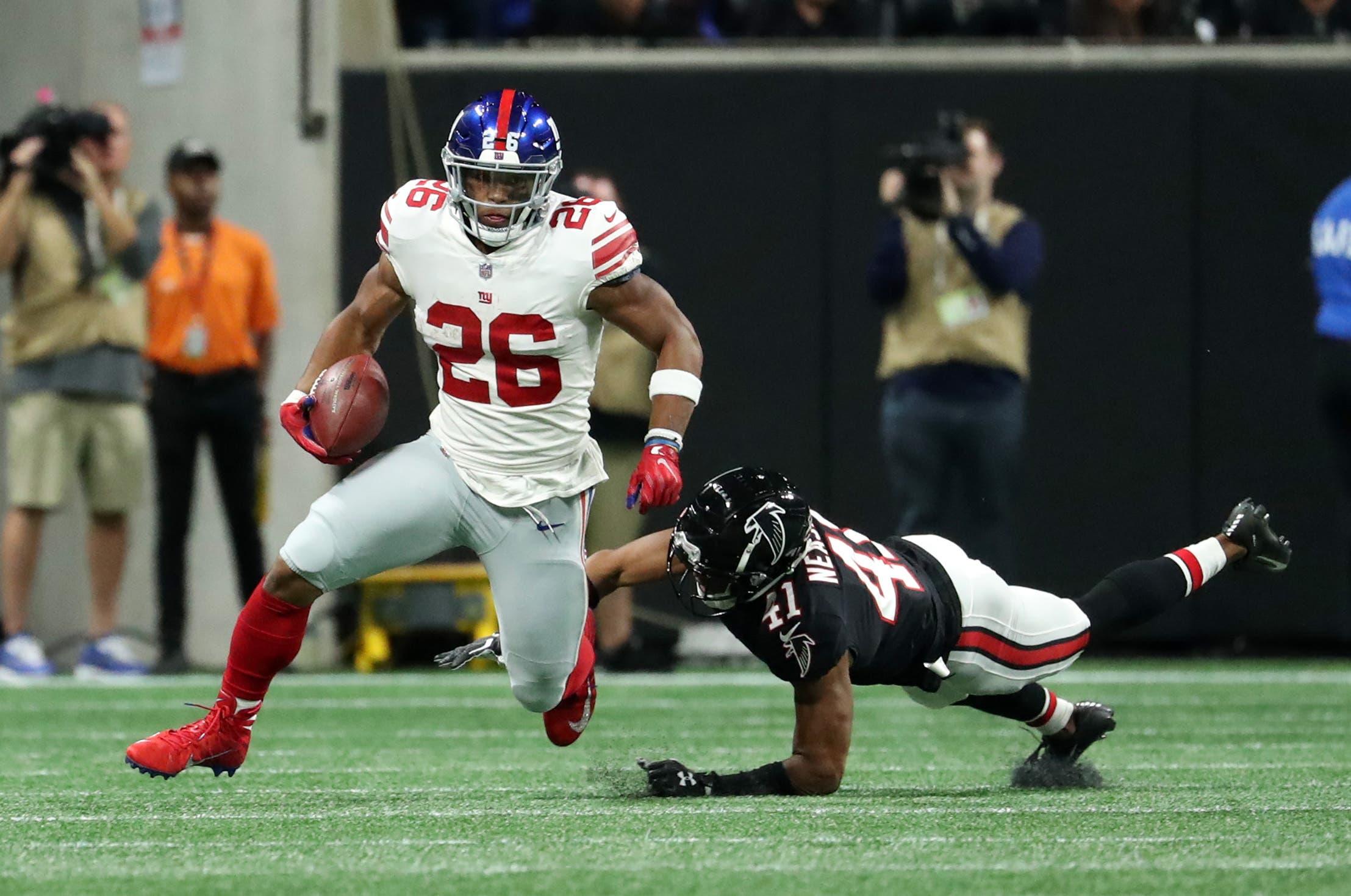 Oct 22, 2018; Atlanta, GA, USA; New York Giants running back Saquon Barkley (26) runs after a catch against Atlanta Falcons defensive back Sharrod Neasman (41) in the first quarter at Mercedes-Benz Stadium. Mandatory Credit: Jason Getz-USA TODAY Sports / Jason Getz