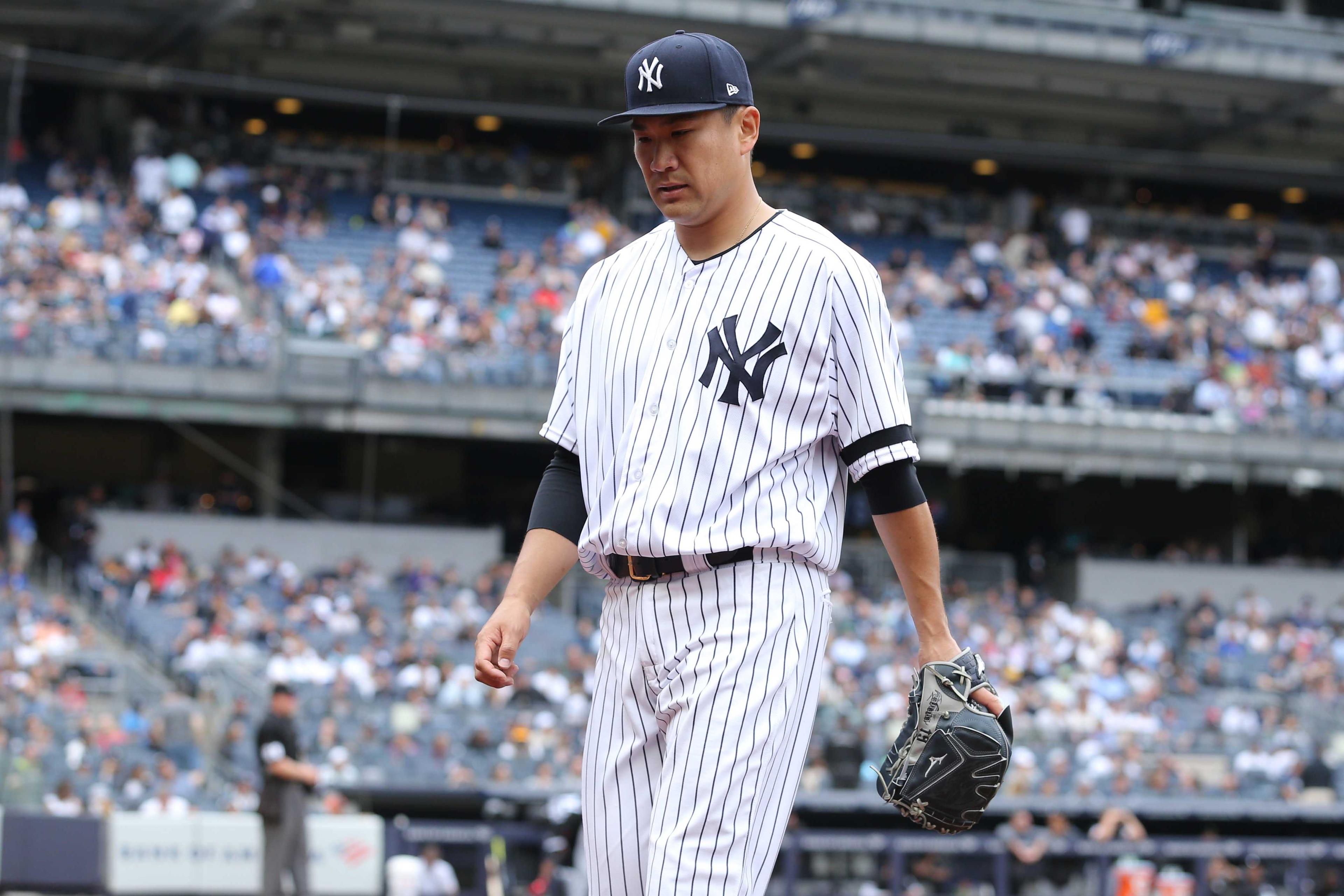 New York Yankees starting pitcher Masahiro Tanaka walks off the mound after being relieved during the fifth inning against the Chicago White Sox at Yankee Stadium.