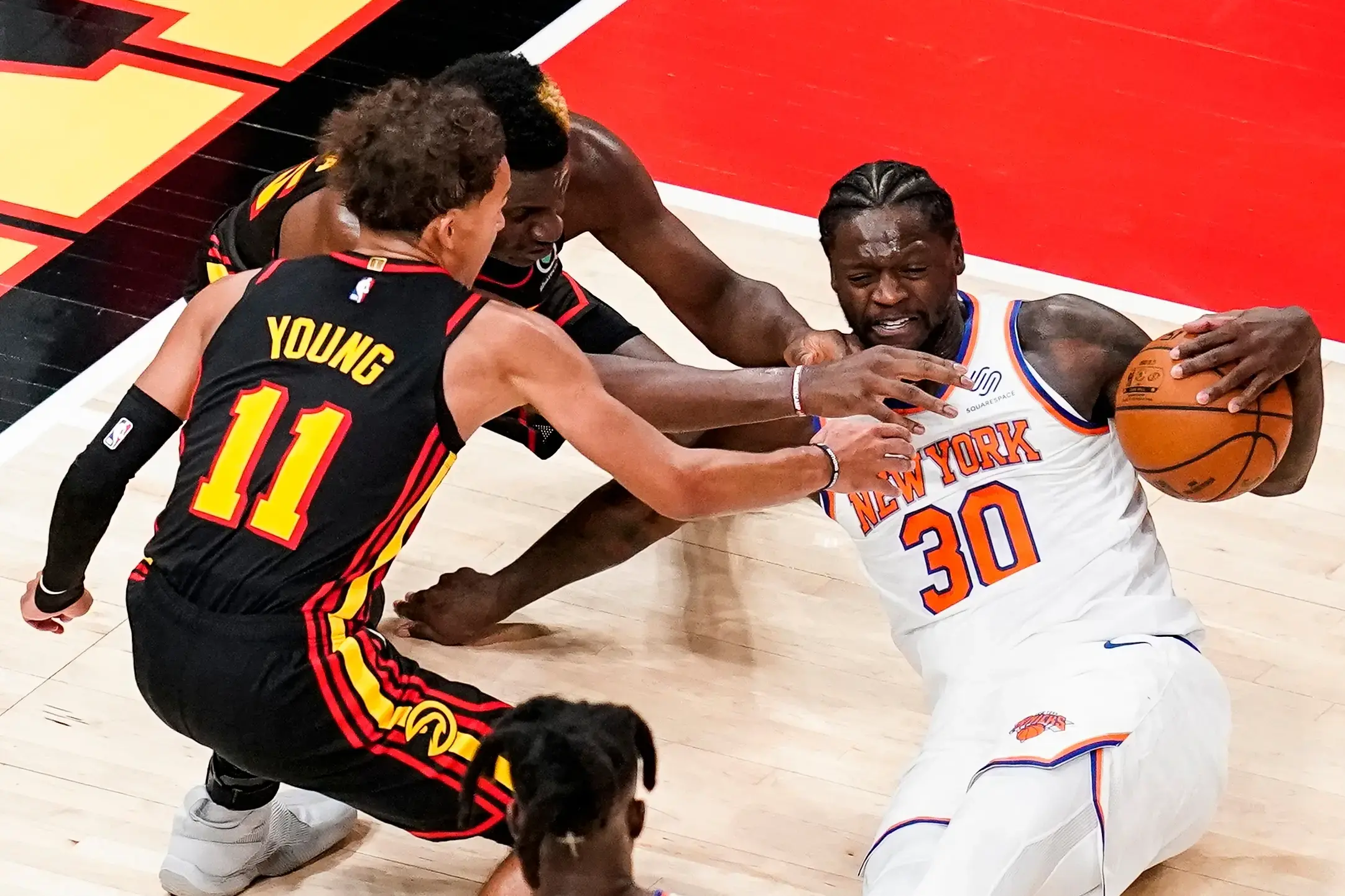 Jan 4, 2021; Atlanta, Georgia, USA; New York Knicks forward Julius Randle (30) grabs a loose ball on the floor in front of Atlanta Hawks guard Trae Young (11) and center Clint Capela (middle) during the second half at State Farm Arena. / © Dale Zanine-USA TODAY Sports