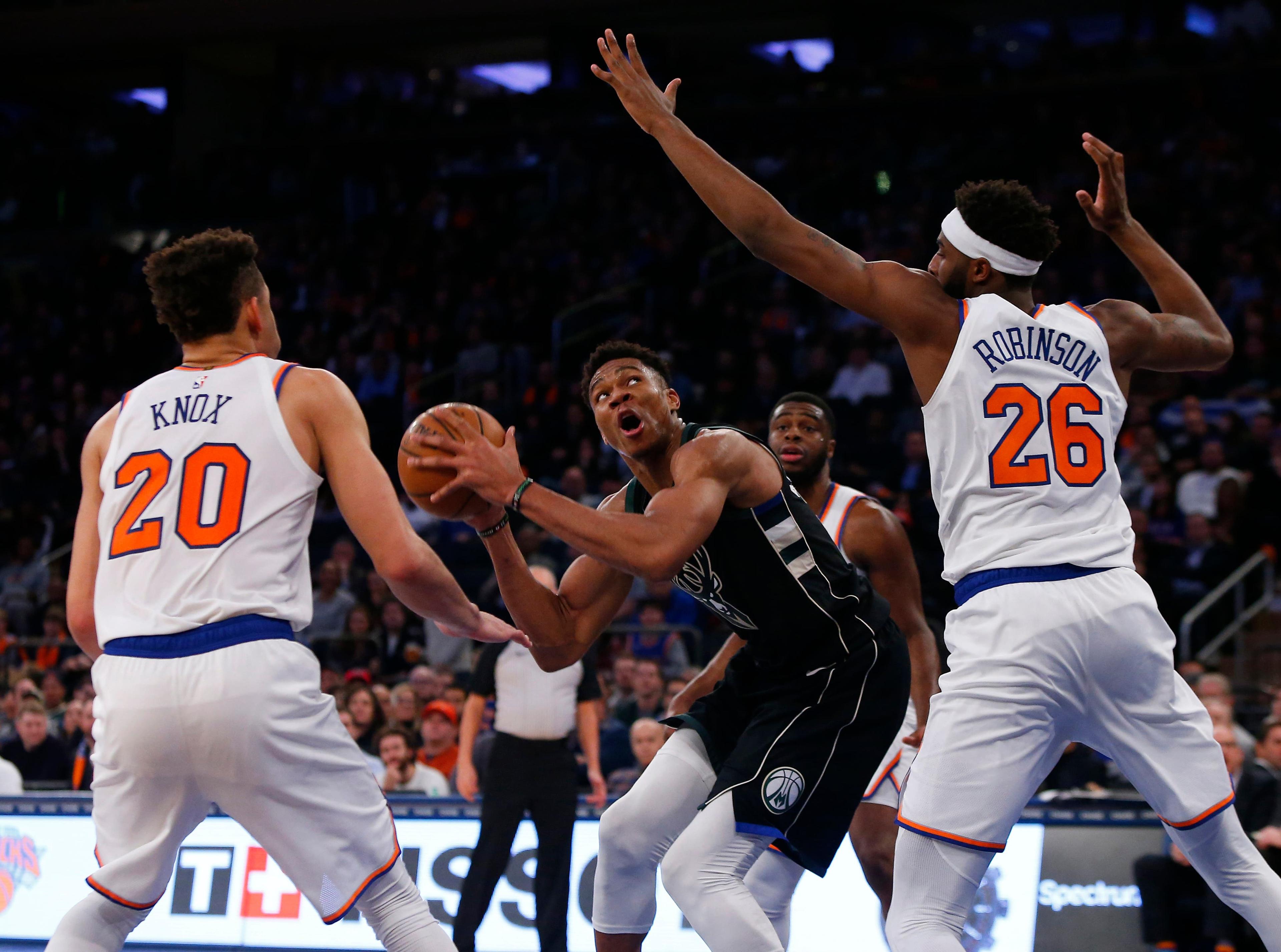 Dec 1, 2018; New York, NY, USA; Milwaukee Bucks forward Giannis Antetokounmpo (34) eyes the basket against New York Knicks forward Kevin Knox (20) and center Mitchell Robinson (26) during overtime at Madison Square Garden. Mandatory Credit: Noah K. Murray-USA TODAY Sports / Noah K. Murray