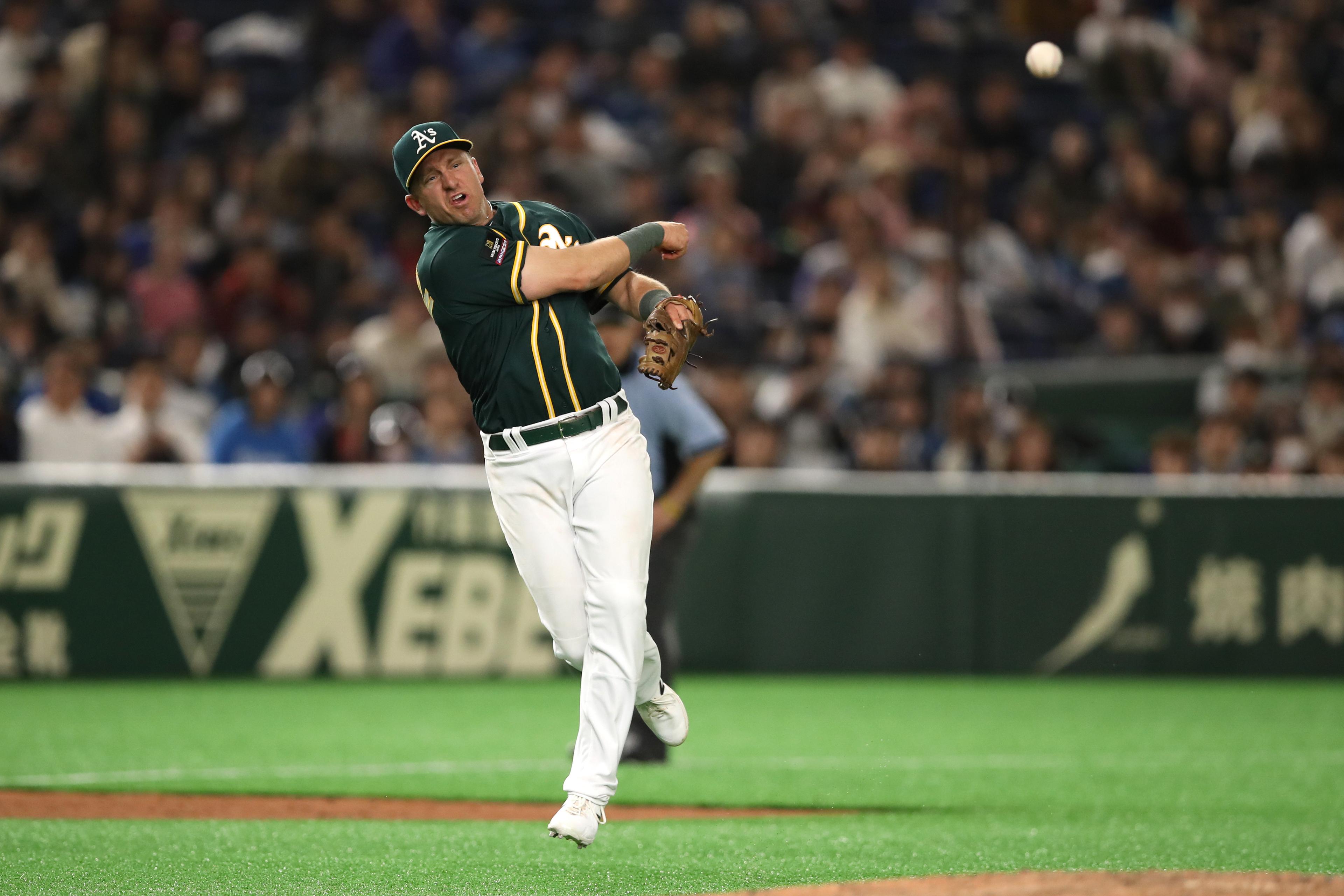 Mar 18, 2019; Tokyo, Japan; Oakland Athletics third baseman Cliff Pennington (15) throws the ball on the run to first base during the eighth inning against the Nippon Ham Fighters at Tokyo Dome. Mandatory Credit: Darren Yamashita-USA TODAY Sports