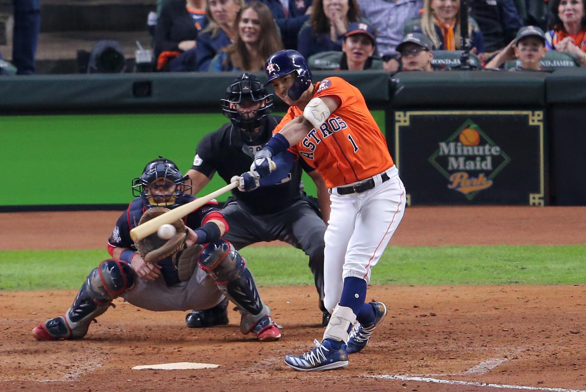 Oct 30, 2019; Houston, TX, USA; Houston Astros shortstop Carlos Correa (1) hits a RBI single against the Washington Nationals during the fifth inning in game seven of the 2019 World Series at Minute Maid Park. Mandatory Credit: Erik Williams-USA TODAY Sports