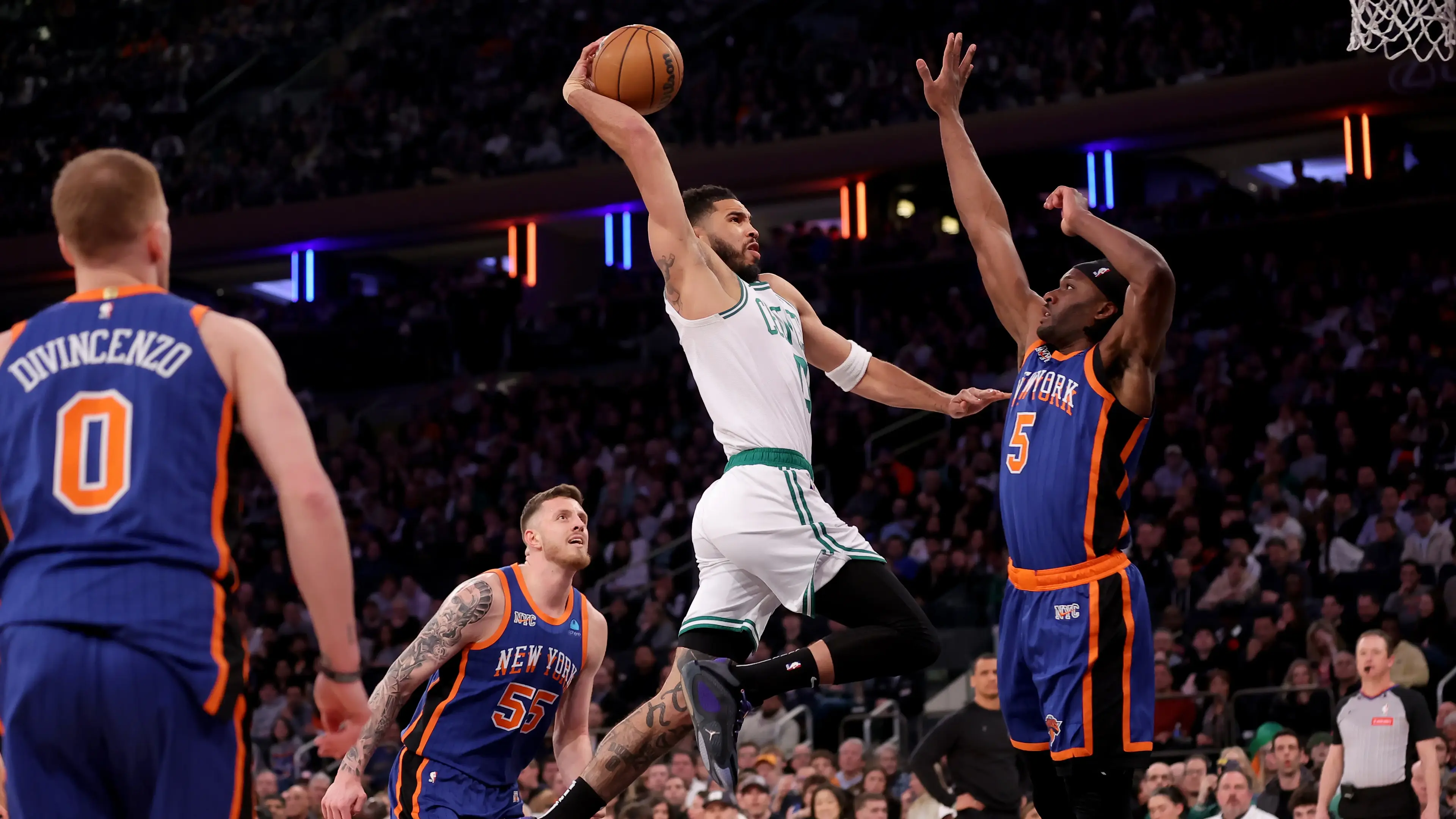 Boston Celtics forward Jayson Tatum (0) drives to the basket against New York Knicks forward Precious Achiuwa (5) and center Isaiah Hartenstein (55) and guard Donte DiVincenzo (0) during the first quarter at Madison Square Garden. / Brad Penner-USA TODAY Sports
