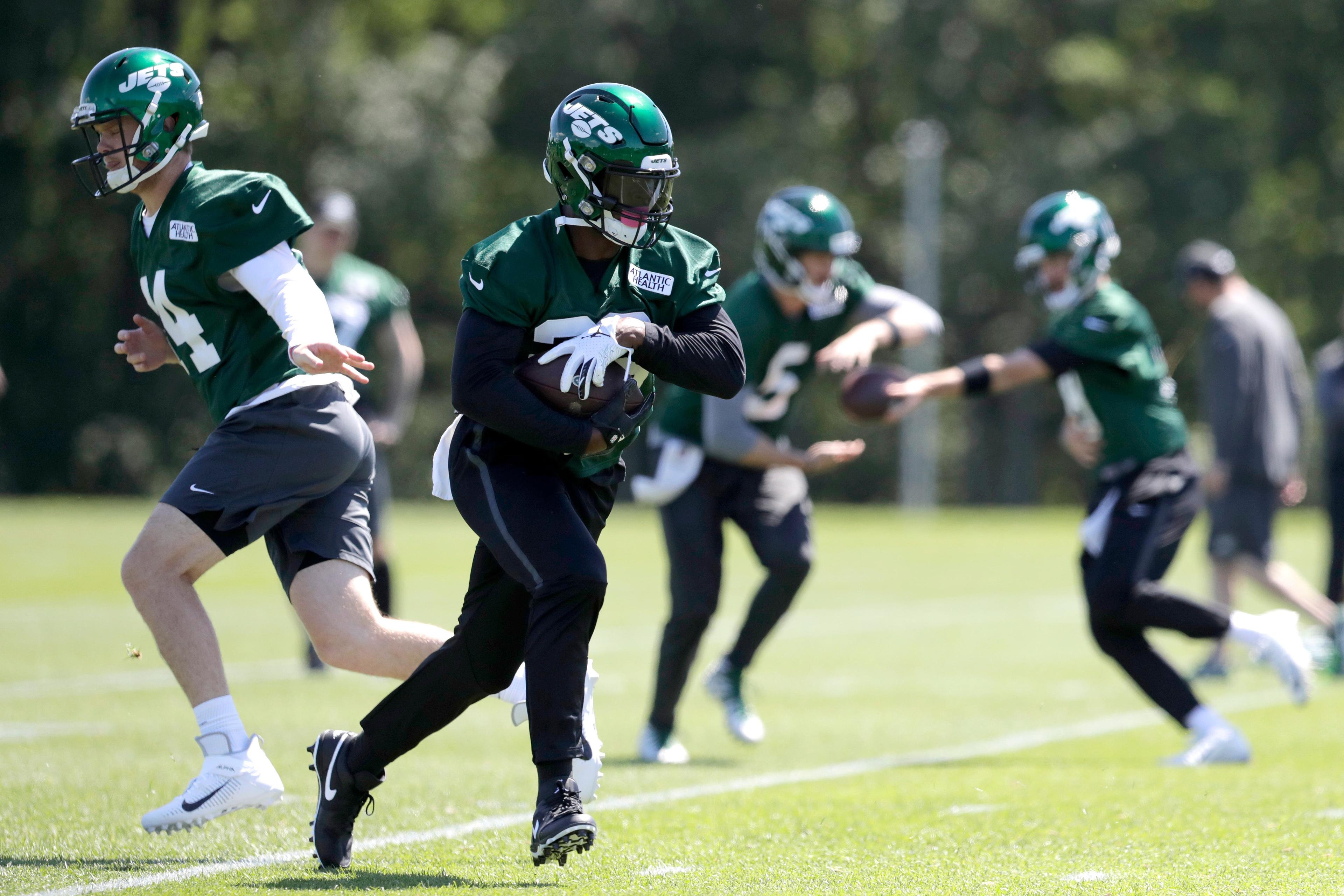 New York Jets quarterback Sam Darnold, left, hands off to running back Le'Veon Bell while running a drill at the team's NFL football training facility in Florham Park, N.J., Tuesday, June 4, 2019. (AP Photo/Julio Cortez) / Julio Cortez/AP