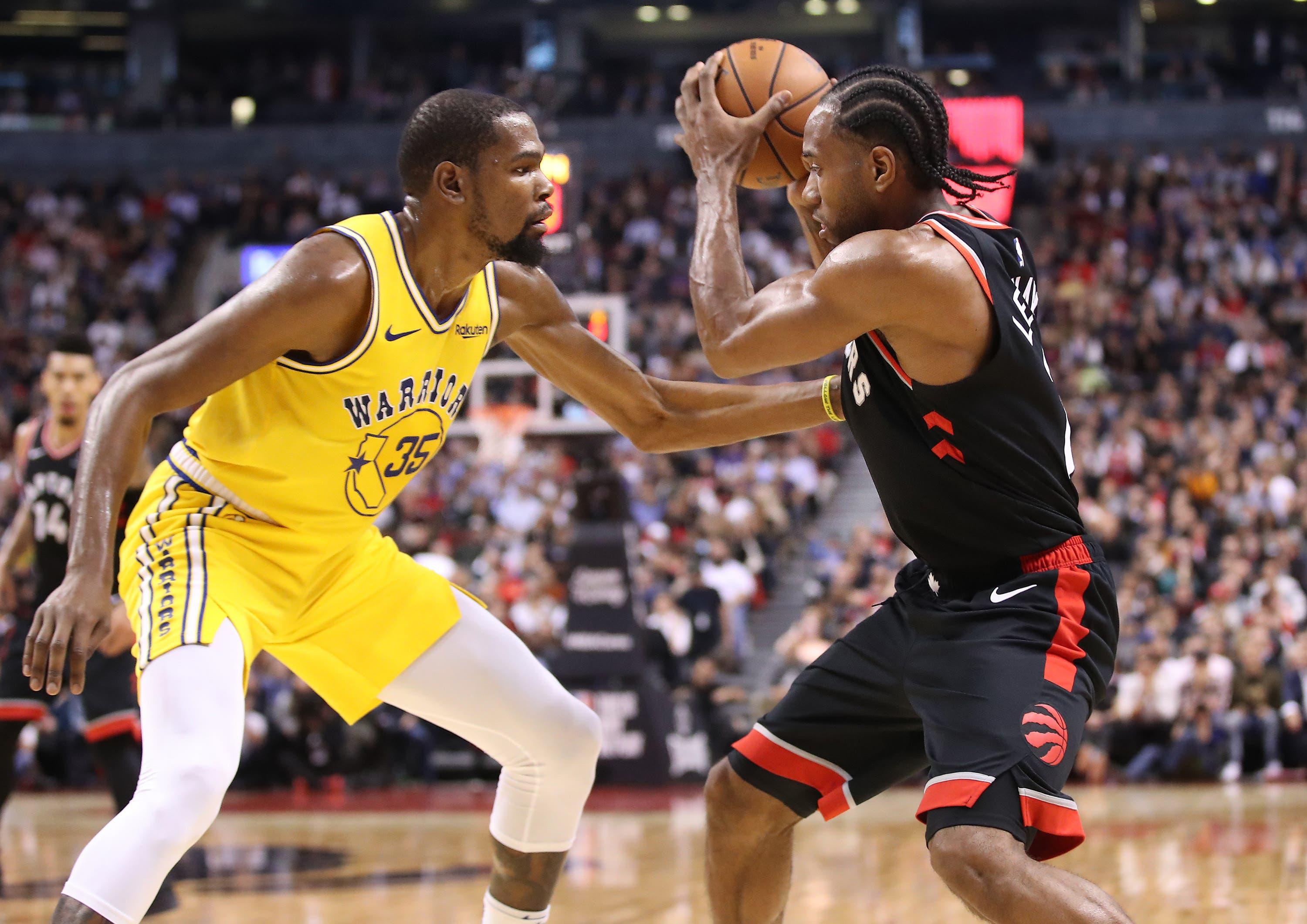 Toronto Raptors forward Kawhi Leonard controls the ball as he is watched closely by Golden State Warriors forward Kevin Durant in the fourth quarter at Scotiabank Arena. / Tom Szczerbowski/USA TODAY Sports