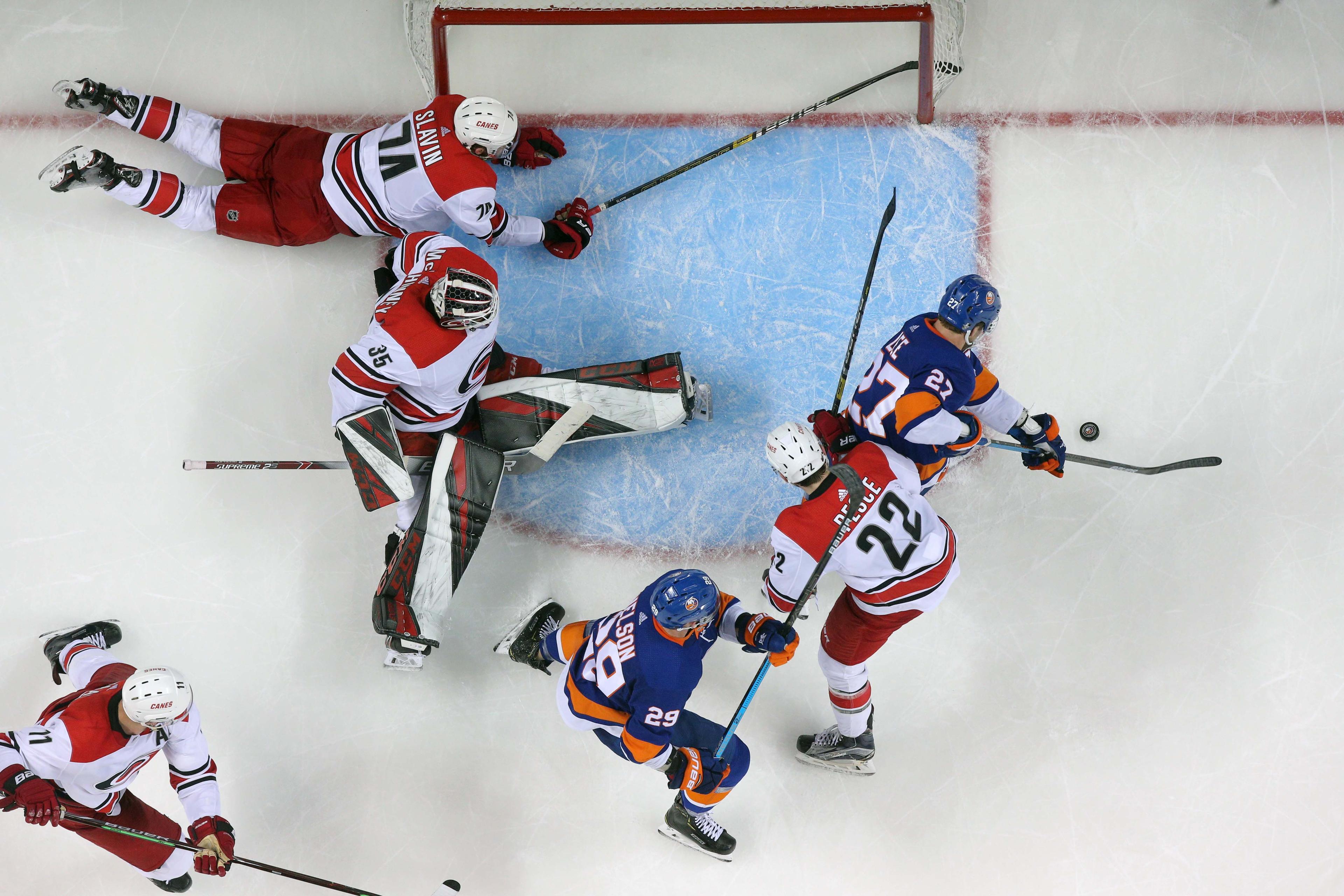 New York Islanders left wing Anders Lee shoots against Carolina Hurricanes goalie Curtis McElhinney in front of Carolina Hurricanes defensemen Jaccob Slavin and Brett Pesce and Islanders center Brock Nelson during the third period of Game 2 of the second round of the 2019 Stanley Cup Playoffs at Barclays Center. / Brad Penner/USA TODAY Sports