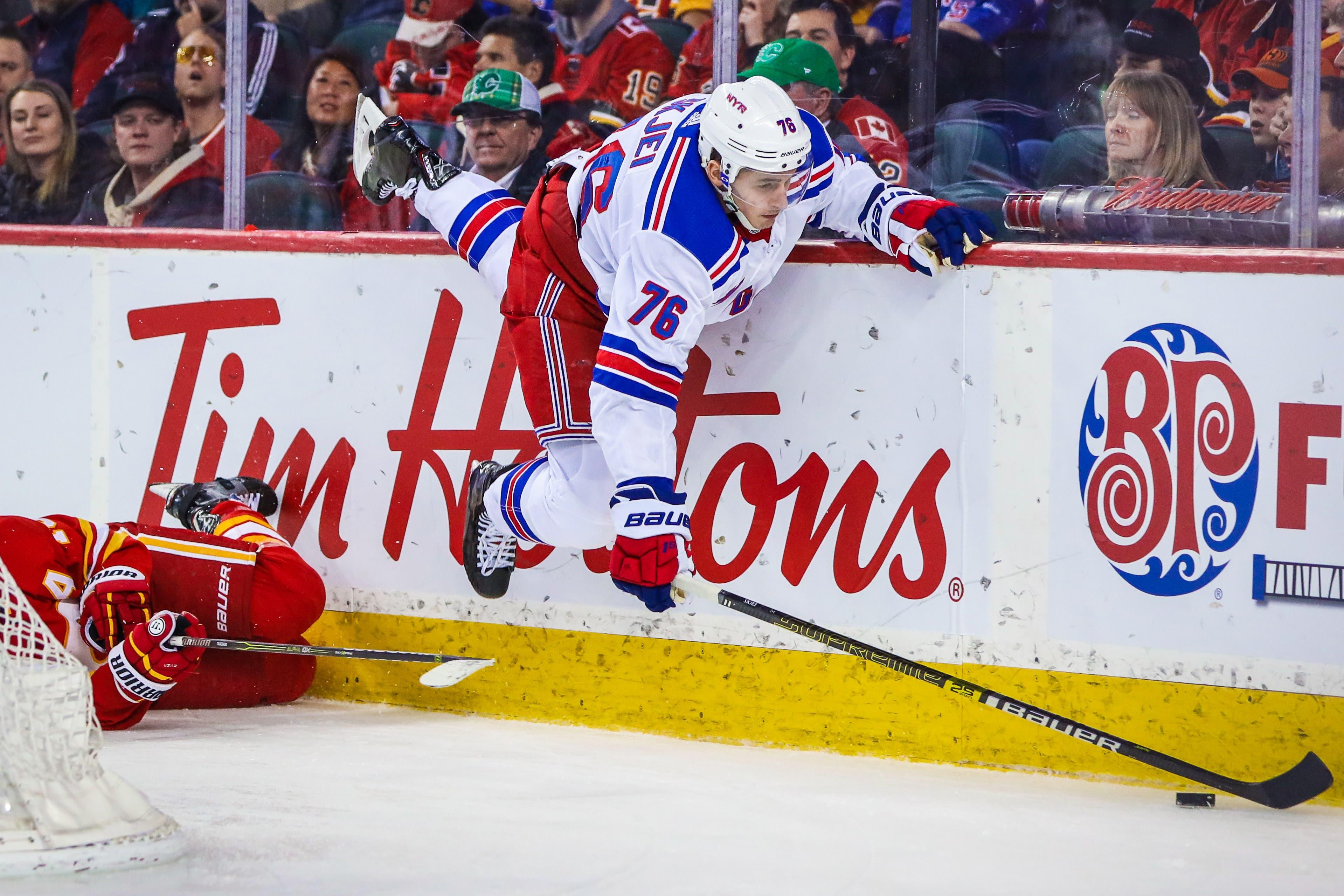 Mar 15, 2019; Calgary, Alberta, CAN; New York Rangers defenseman Brady Skjei (76) and Calgary Flames left wing Matthew Tkachuk (19) battle for the puck during the third period at Scotiabank Saddledome. Calgary Flames won 5-1. Mandatory Credit: Sergei Belski-USA TODAY Sports / Sergei Belski