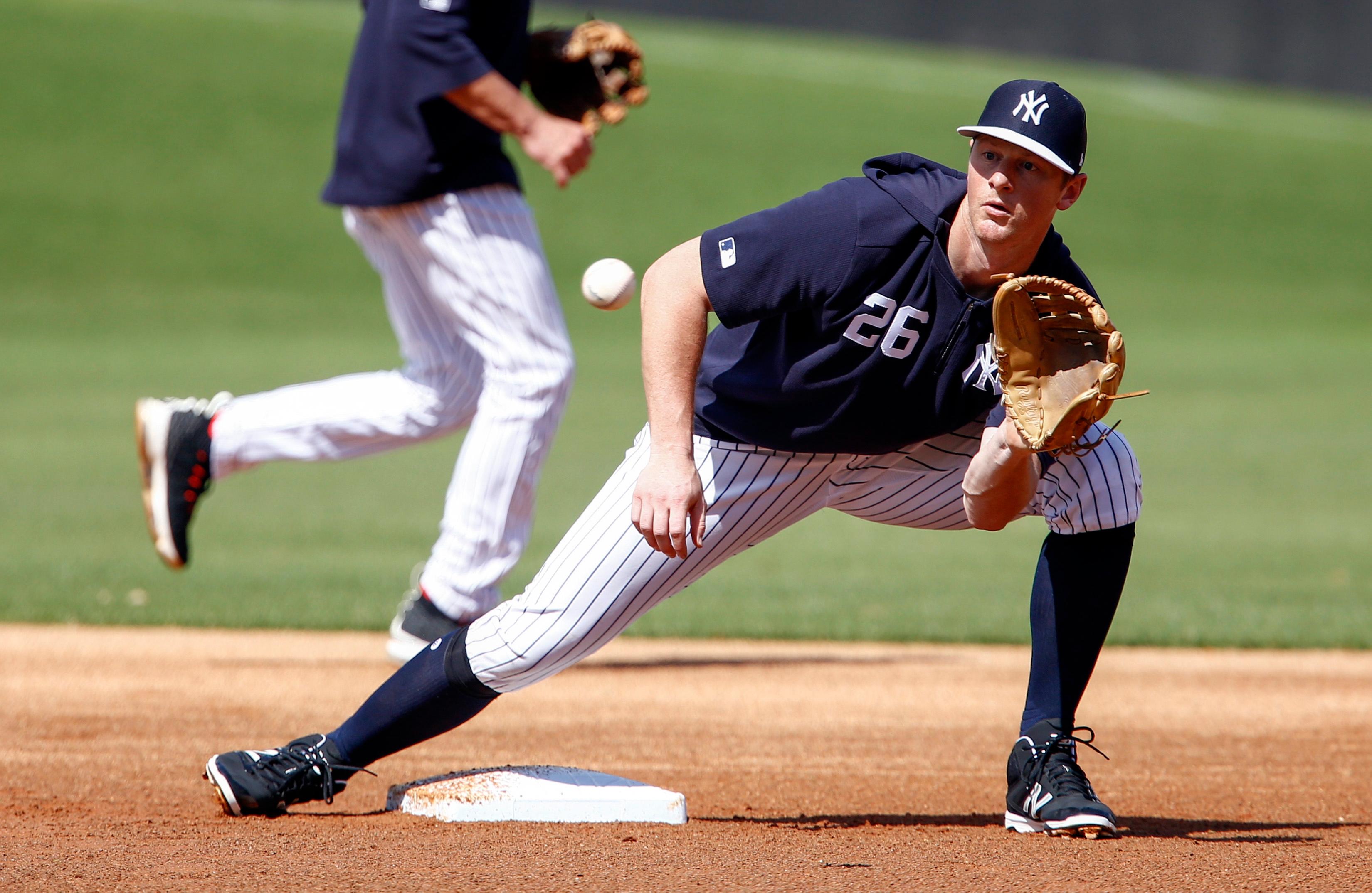 New York Yankees infielder DJ LeMahieu catches a ball thrown from home plate in a steal drill during spring training workouts at George M. Steinbrenner Field.