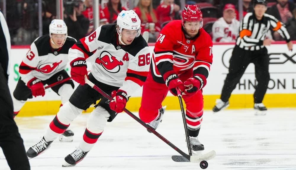 New Jersey Devils center Jack Hughes (86) skates with the puck past Carolina Hurricanes defenseman Jaccob Slavin (74) during the second period at PNC Arena.