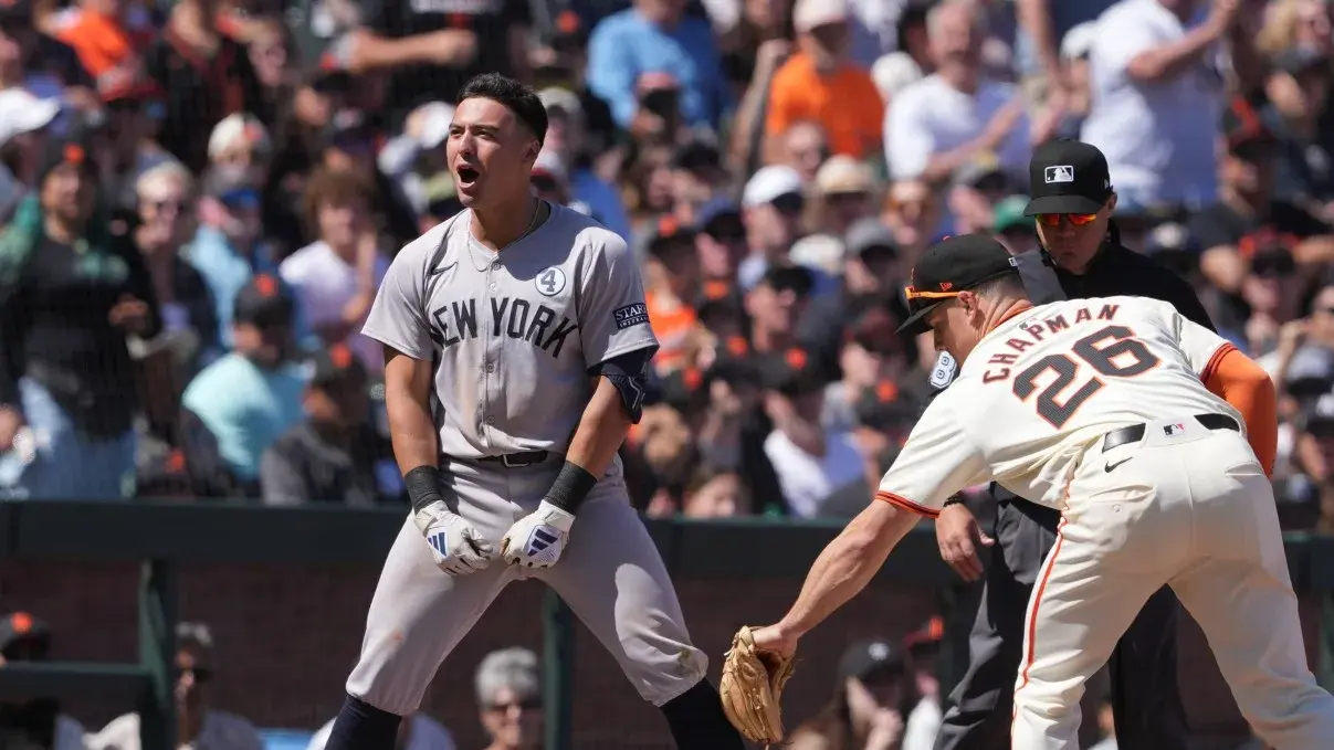 New York Yankees shortstop Anthony Volpe (left) reacts after hitting a triple as San Francisco Giants third baseman Matt Chapman (26) applies a late tag during the ninth inning at Oracle Park. / Darren Yamashita-USA TODAY Sports