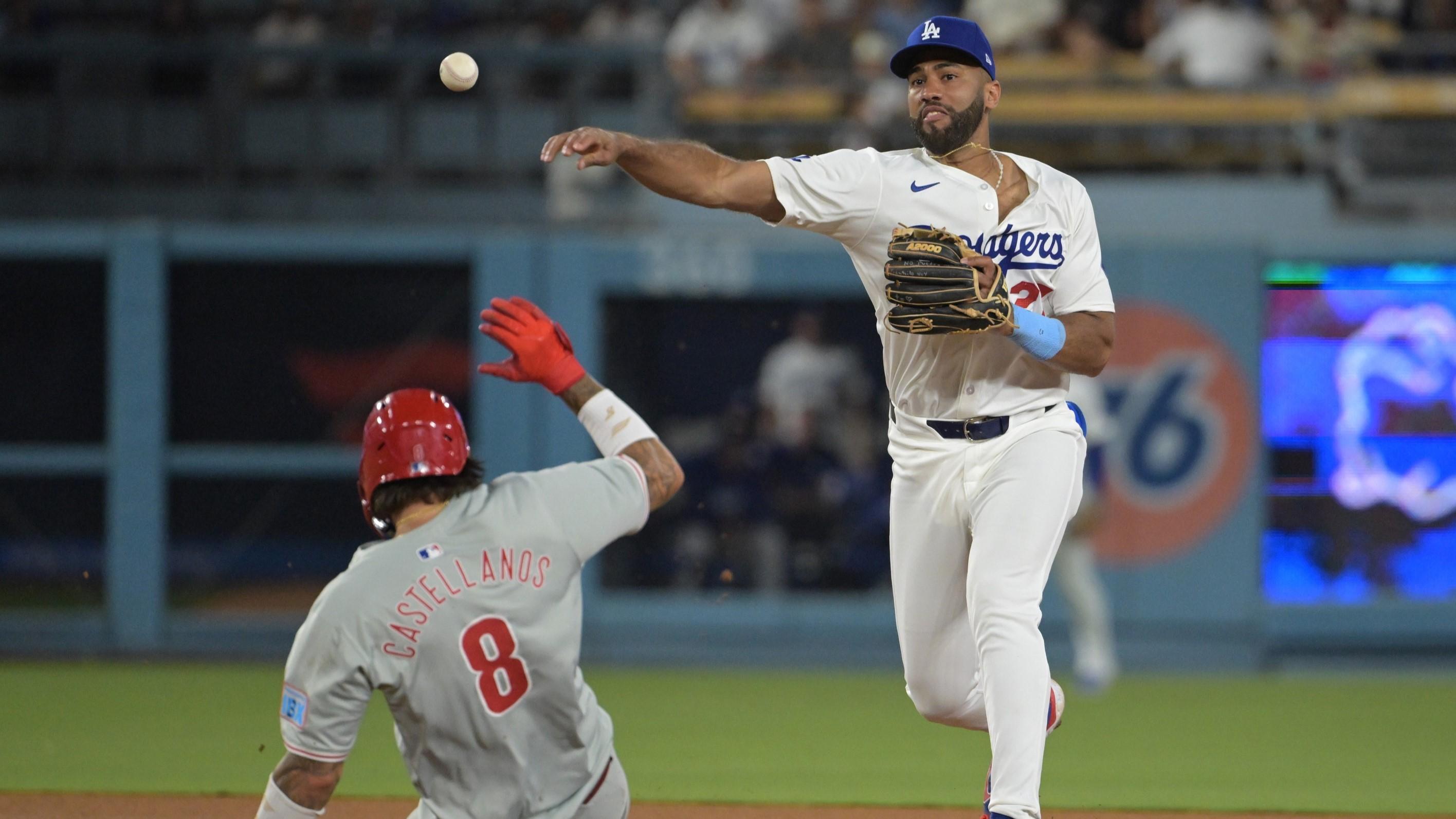 Aug 6, 2024; Los Angeles, California, USA; Philadelphia Phillies right fielder Nick Castellanos (9) is out at second as Los Angeles Dodgers right fielder Amed Rosario (27) throws to first for a double play in the eighth inning at Dodger Stadium.