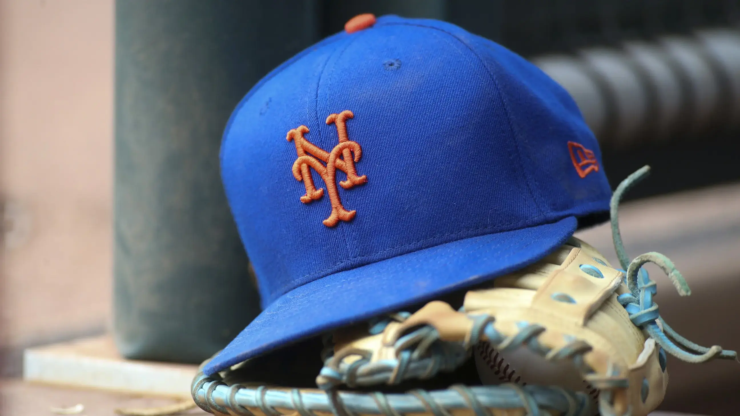 Jul 13, 2022; Atlanta, Georgia, USA; A detailed view of a New York Mets hat and glove in the dugout against the Atlanta Braves in the eighth inning at Truist Park. / Brett Davis-USA TODAY Sports
