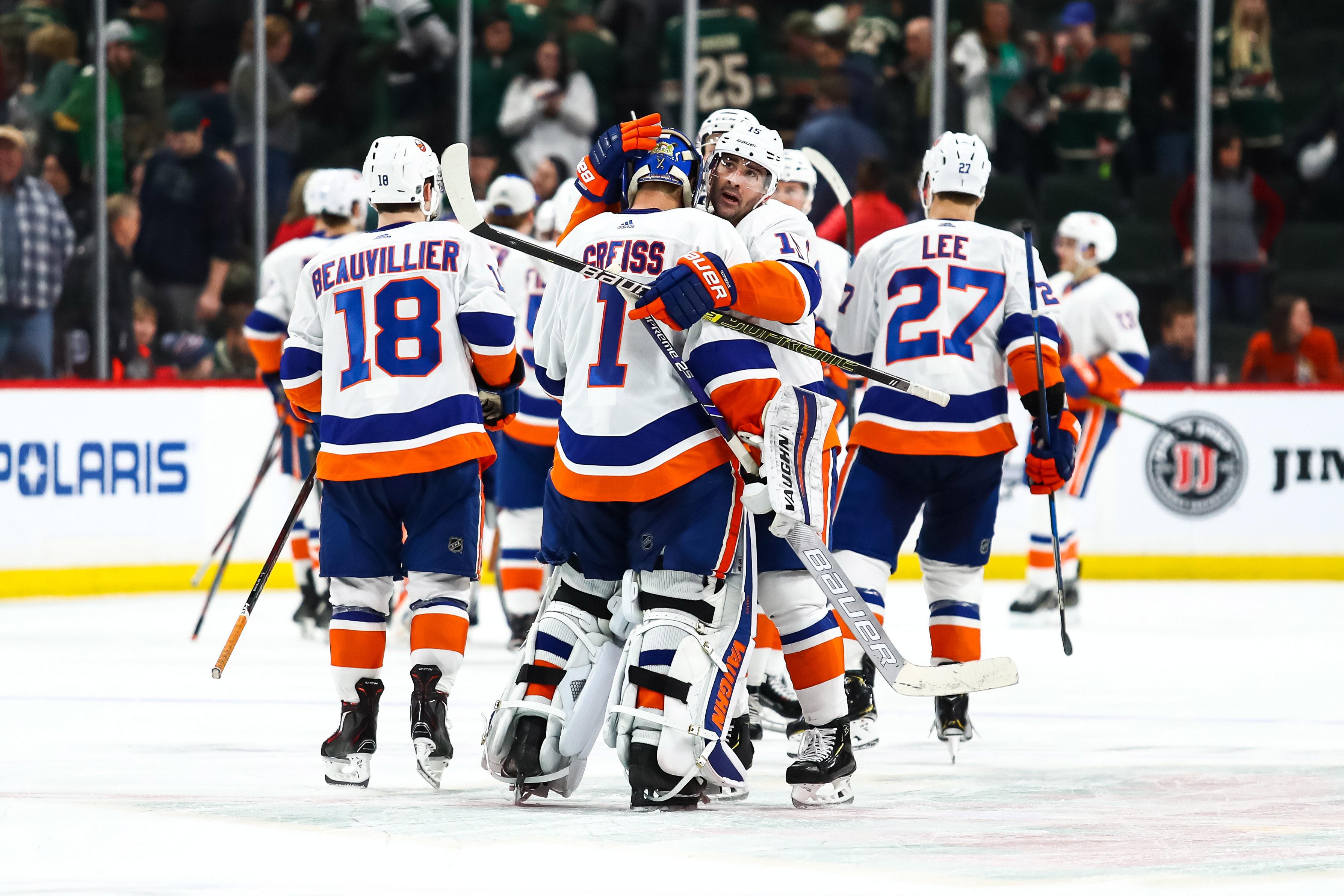 New York Islanders goaltender Thomas Greiss is congratulated by his teammates after the Islanders defeated the Minnesota Wild 3-2 in overtime at Xcel Energy Center.