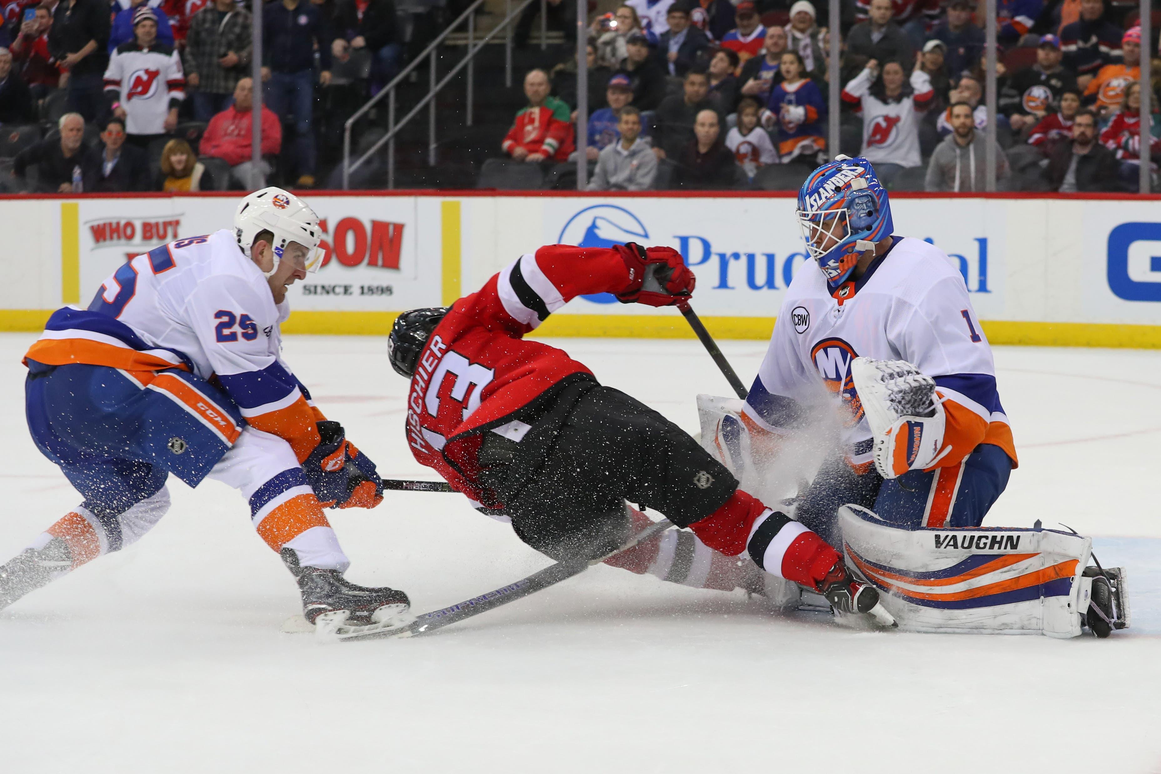 Feb 7, 2019; Newark, NJ, USA; New Jersey Devils center Nico Hischier (13) crashes into New York Islanders goaltender Thomas Greiss (1) after a save by Greiss during the third period at Prudential Center. Mandatory Credit: Ed Mulholland-USA TODAY Sports / Ed Mulholland