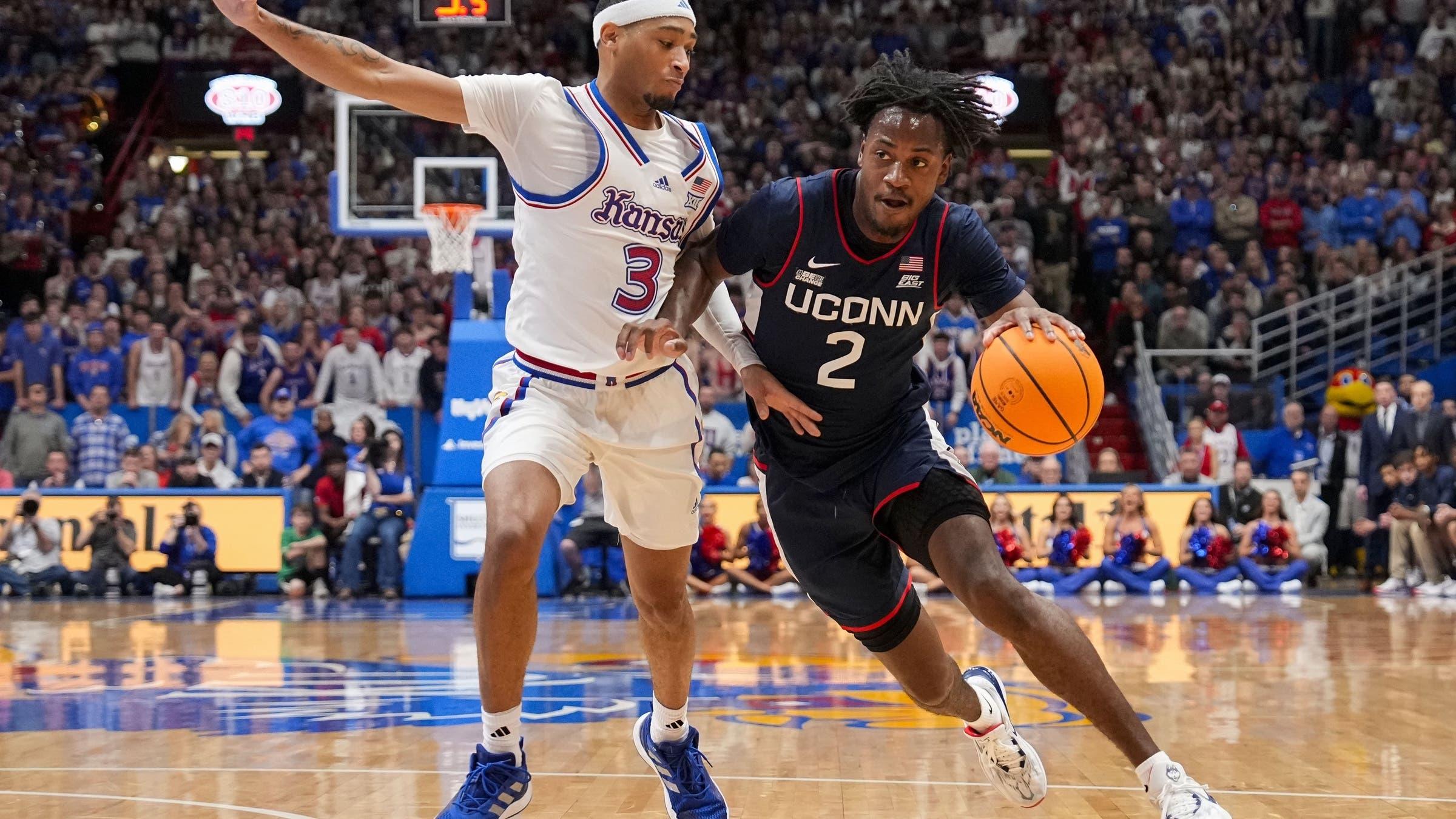 Connecticut Huskies guard Tristen Newton (2) drives against Kansas Jayhawks guard Dajuan Harris Jr. (3) during the first half at Allen Fieldhouse. / Jay Biggerstaff-USA TODAY Sports