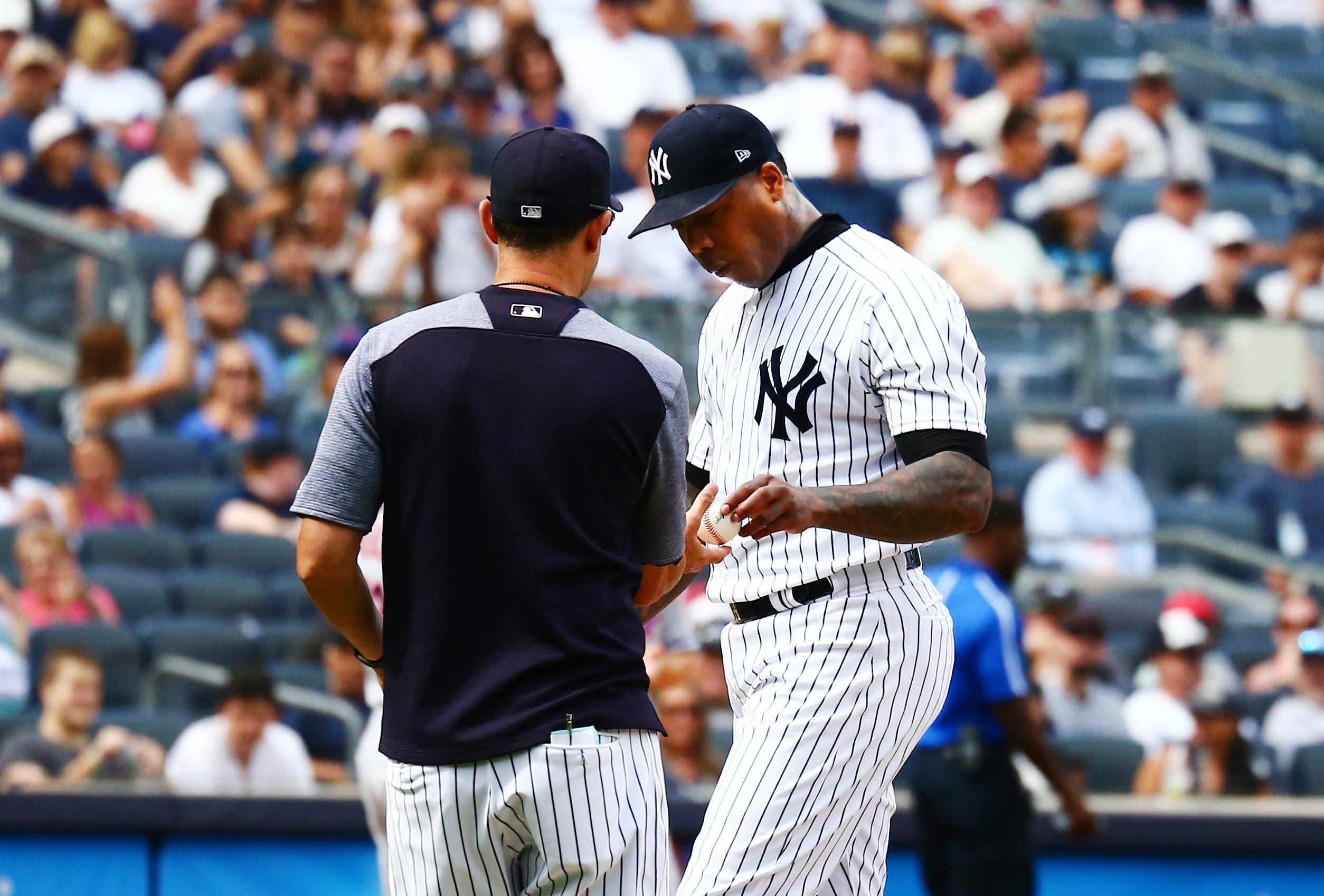 Jul 21, 2018; Bronx, NY, USA; New York Yankees relief pitcher Aroldis Chapman (54) hands the ball to manager Aaron Boone (17) after being taken out of the game against the New York Mets after giving up three runs during the ninth inning at Yankee Stadium. Mandatory Credit: Andy Marlin-USA TODAY Sports / Andy Marlin