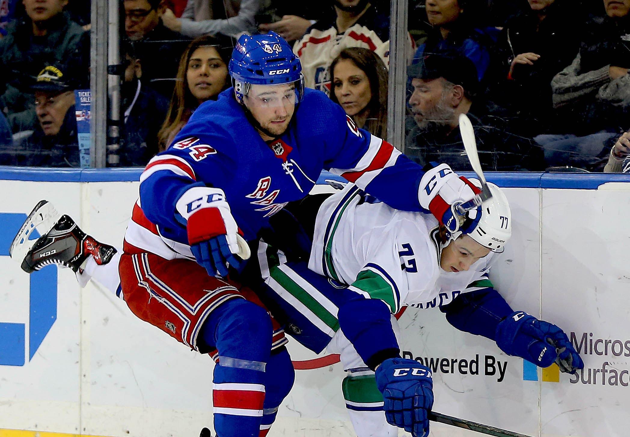 New York Rangers defenseman Neal Pionk and Vancouver Canucks right wing Nikolay Goldobin battle position during the first period at Madison Square Garden. / Andy Marlin/USA TODAY Sports