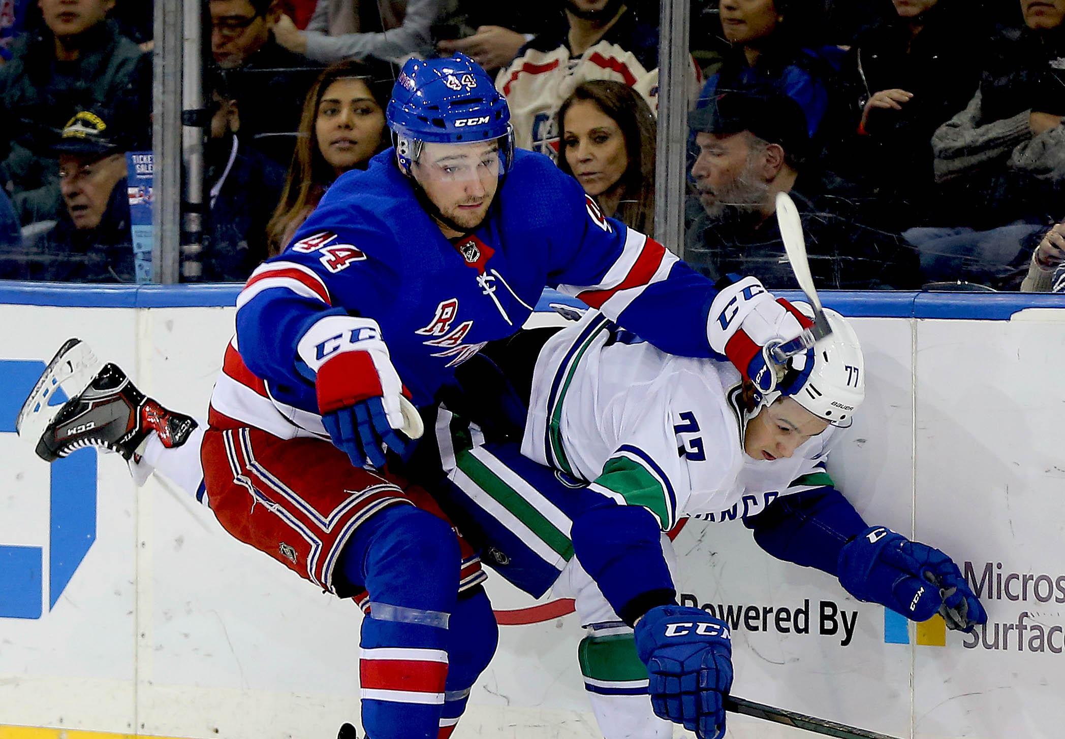 New York Rangers defenseman Neal Pionk and Vancouver Canucks right wing Nikolay Goldobin battle position during the first period at Madison Square Garden.