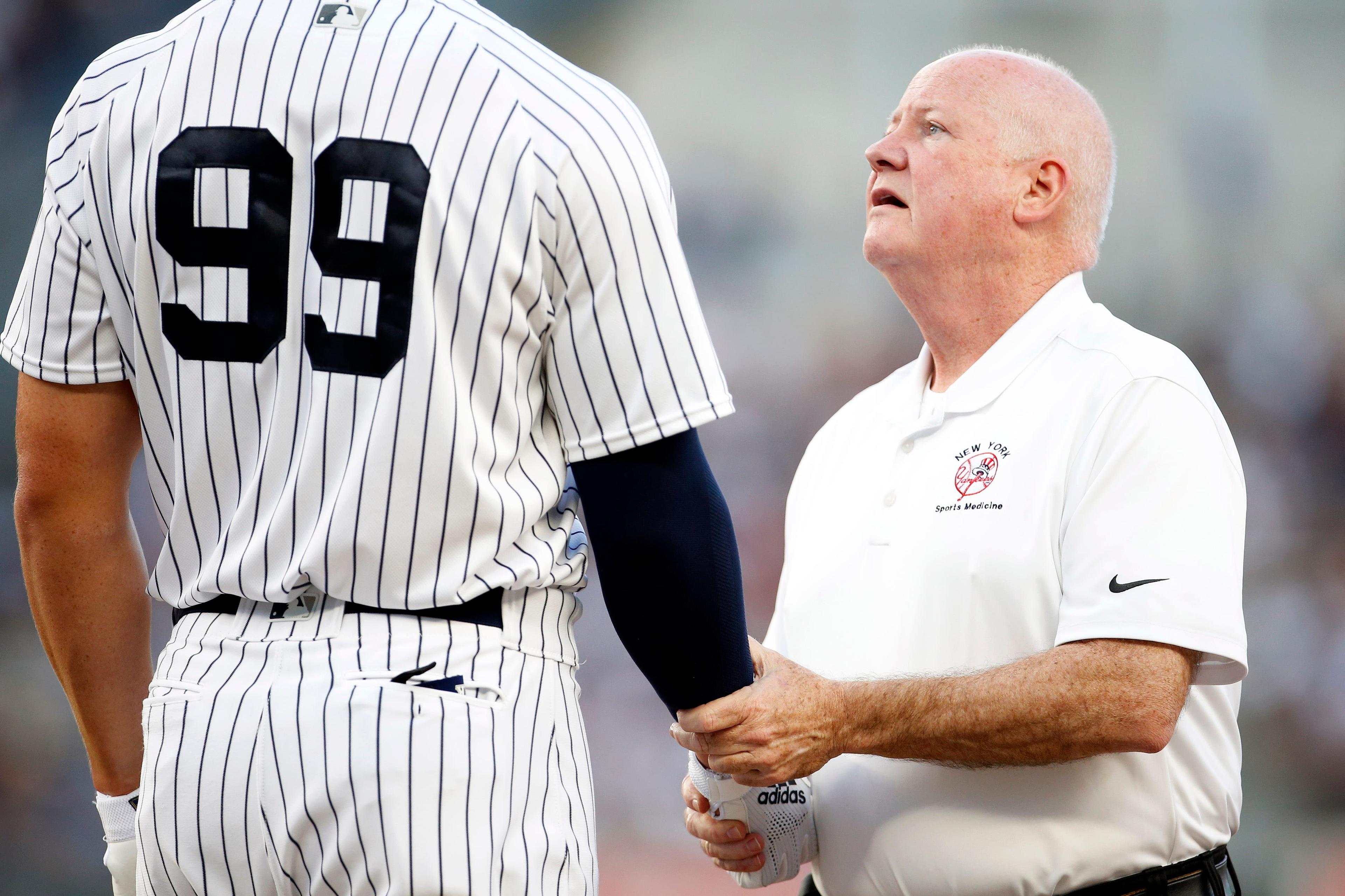 New York Yankees designated hitter Aaron Judge is checked on by Yankees trainer Steve Donohue after being hit by a pitch against the Kansas City Royals during the first inning at Yankee Stadium. / Adam Hunger/USA TODAY Sports