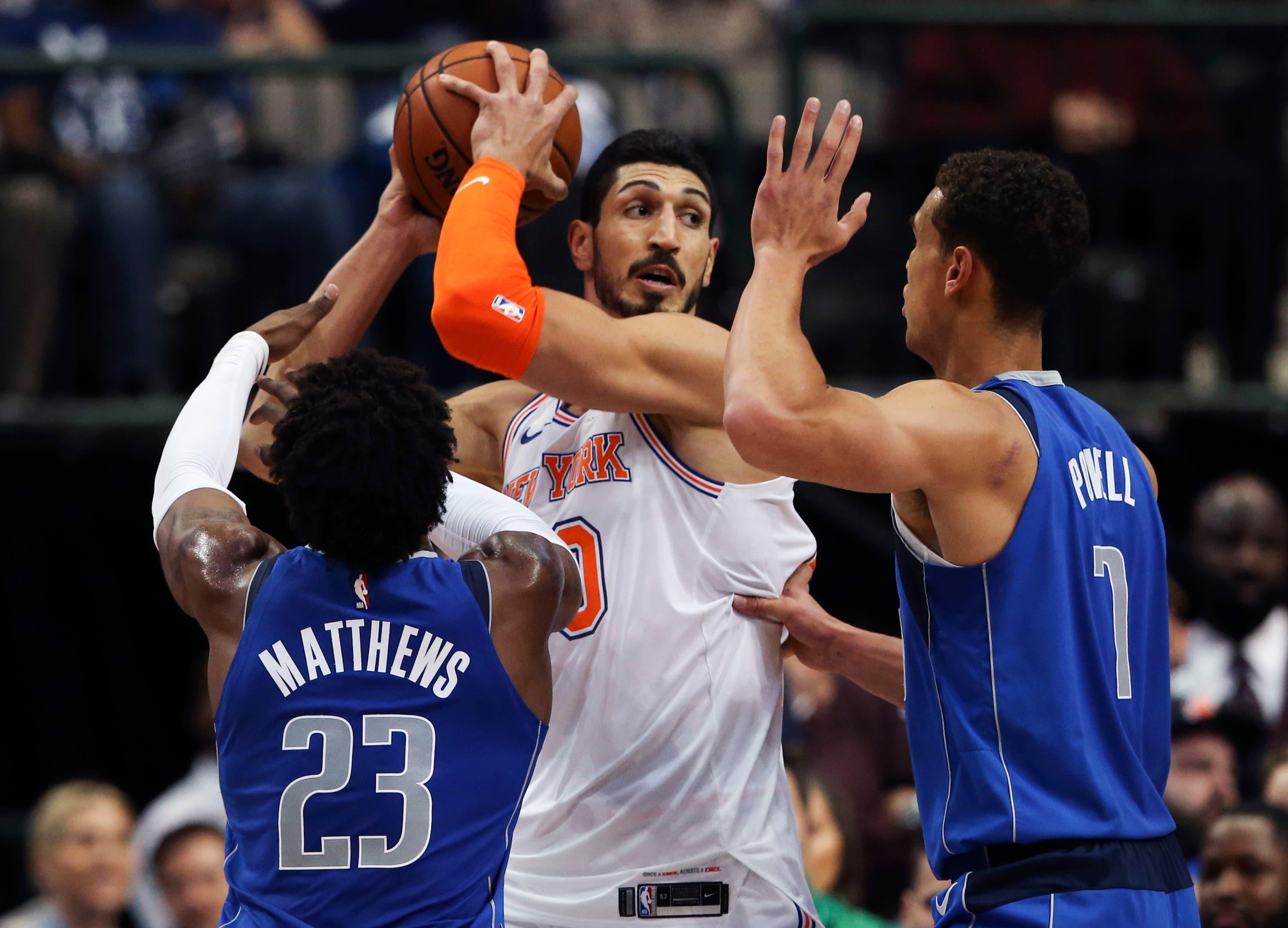 New York Knicks center Enes Kanter looks to pass as Dallas Mavericks guard Wesley Matthews and forward Dwight Powell defend during the first half at American Airlines Center. / Kevin Jairaj/USA TODAY Sports