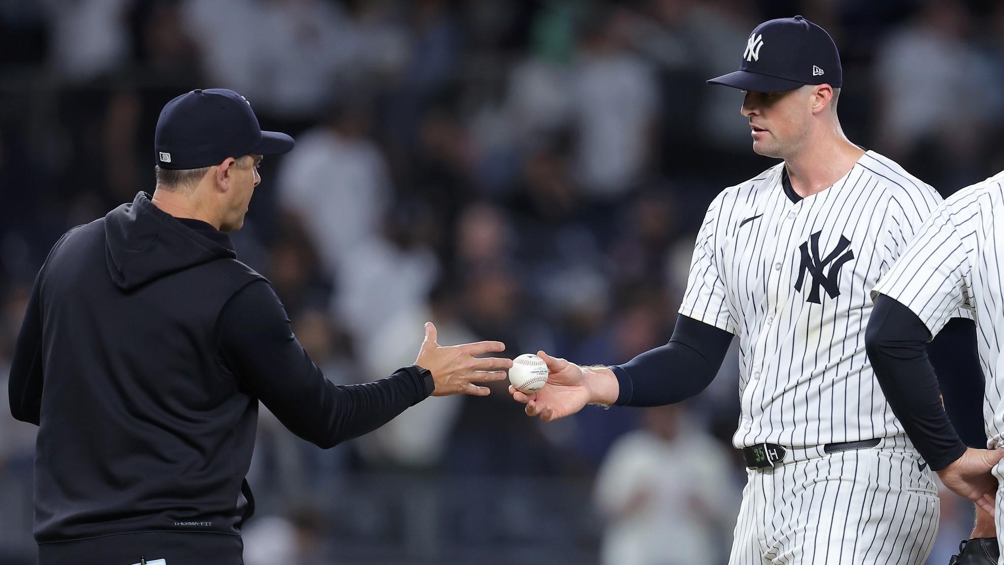 May 20, 2024; Bronx, New York, USA; New York Yankees relief pitcher Clay Holmes (35) hands the ball to manager Aaron Boone (17) after being taken out of the game against the Seattle Mariners during the ninth inning at Yankee Stadium. / Brad Penner-USA TODAY Sports