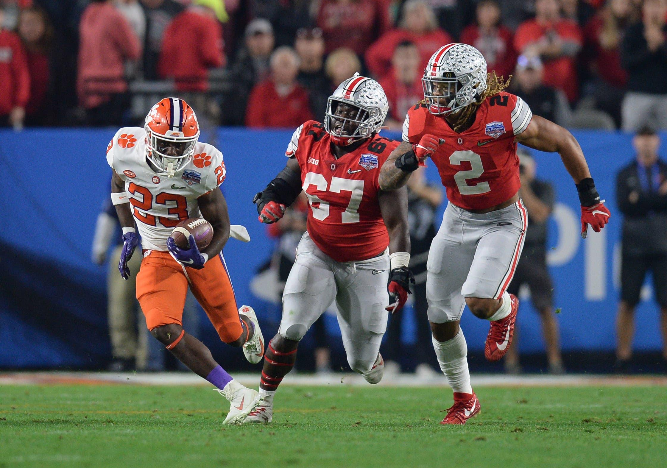 Dec 28, 2019; Glendale, AZ, USA; Clemson Tigers running back Lyn-J Dixon (23) runs the ball against Ohio State Buckeyes defensive end Chase Young (2) and defensive lineman Robert Landers (67) during the third quarter in the 2019 Fiesta Bowl college football playoff semifinal game at State Farm Stadium. Mandatory Credit: Joe Camporeale-USA TODAY Sports / Joe Camporeale