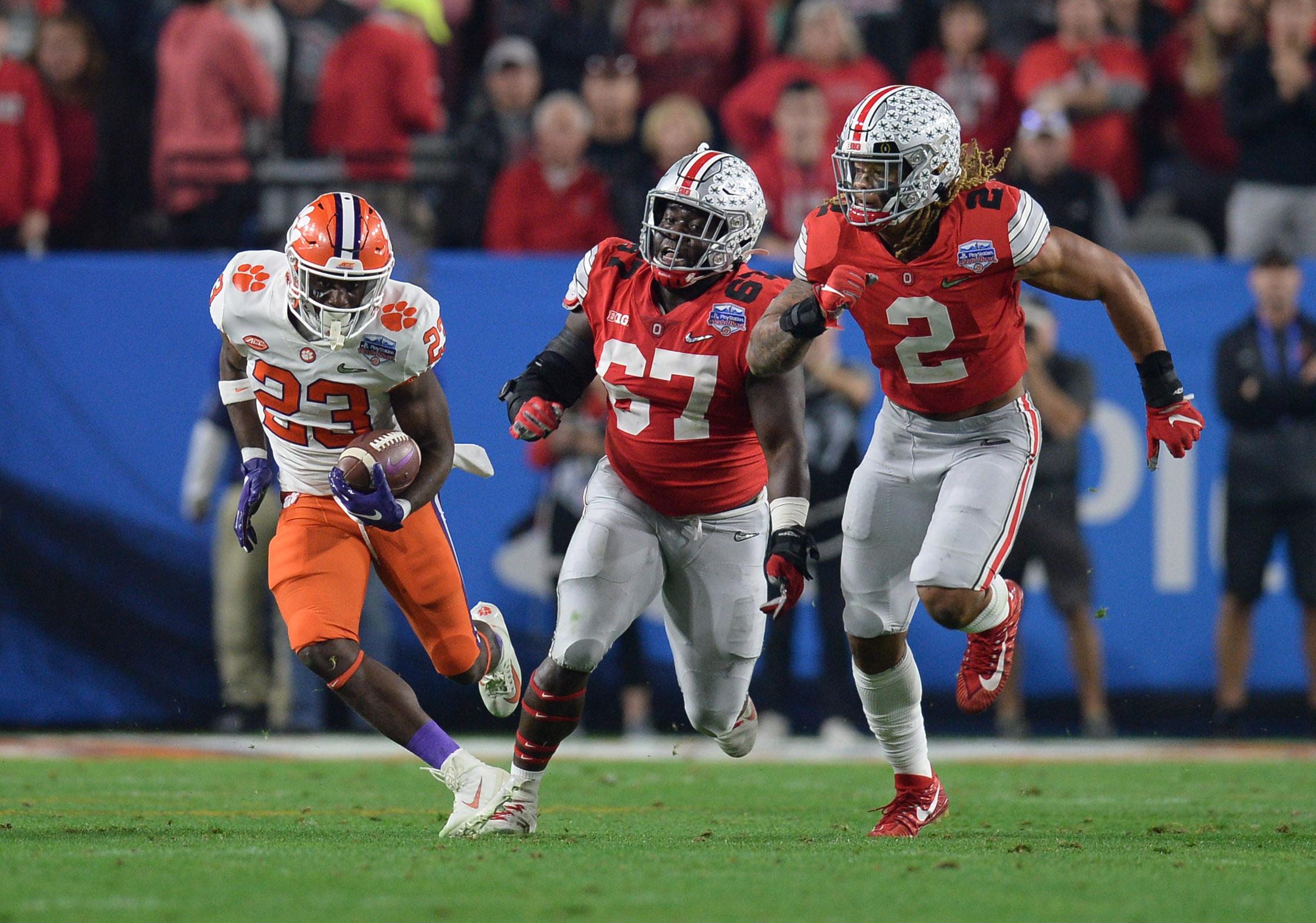 Dec 28, 2019; Glendale, AZ, USA; Clemson Tigers running back Lyn-J Dixon (23) runs the ball against Ohio State Buckeyes defensive end Chase Young (2) and defensive lineman Robert Landers (67) during the third quarter in the 2019 Fiesta Bowl college football playoff semifinal game at State Farm Stadium. Mandatory Credit: Joe Camporeale-USA TODAY Sports