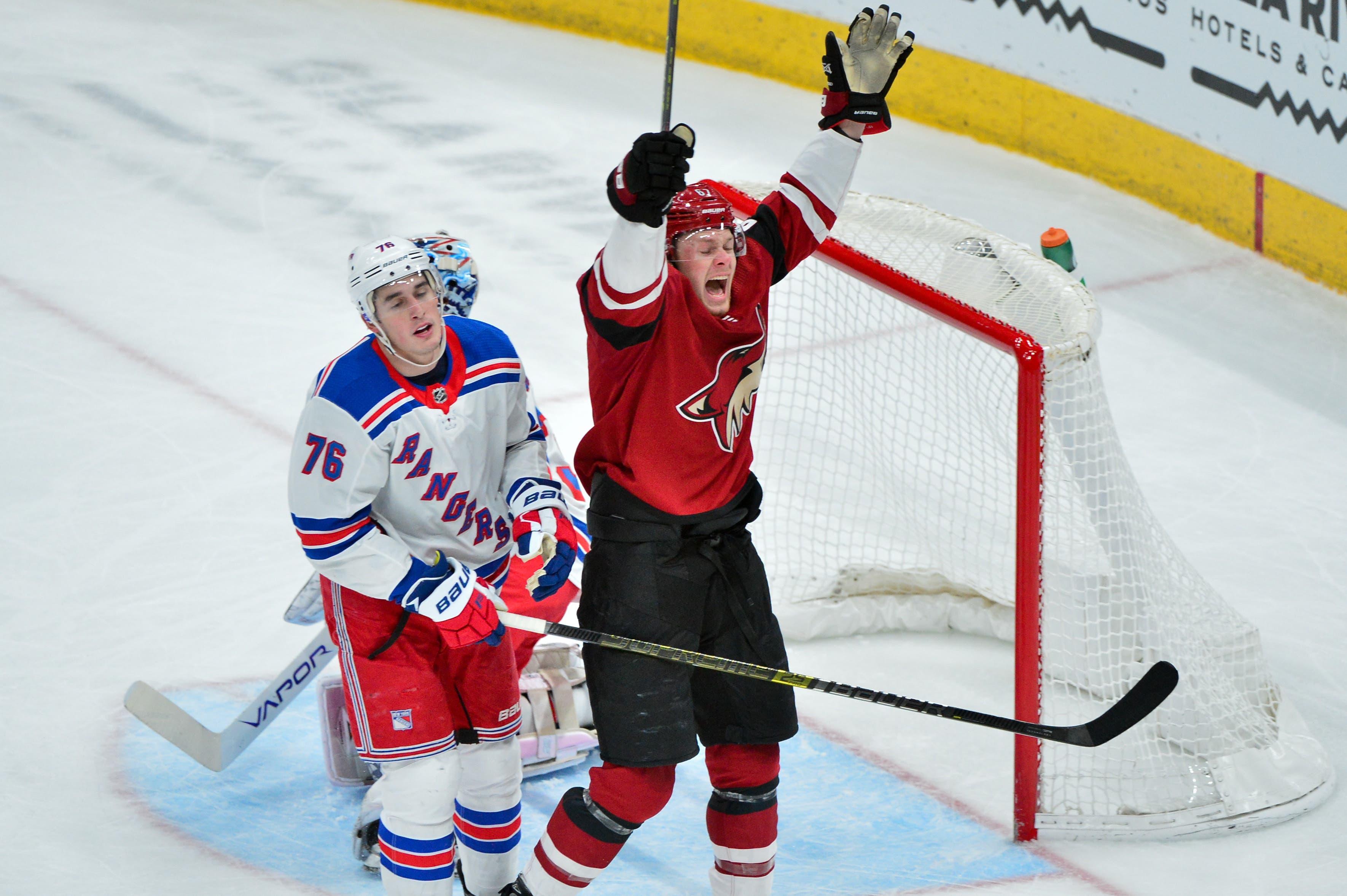 Arizona Coyotes left wing Lawson Crouse and New York Rangers defenseman Brady Skjei react after a goal buy Arizona Coyotes right wing Mario Kempe in the first period at Gila River Arena. / Matt Kartozian/USA TODAY Sports